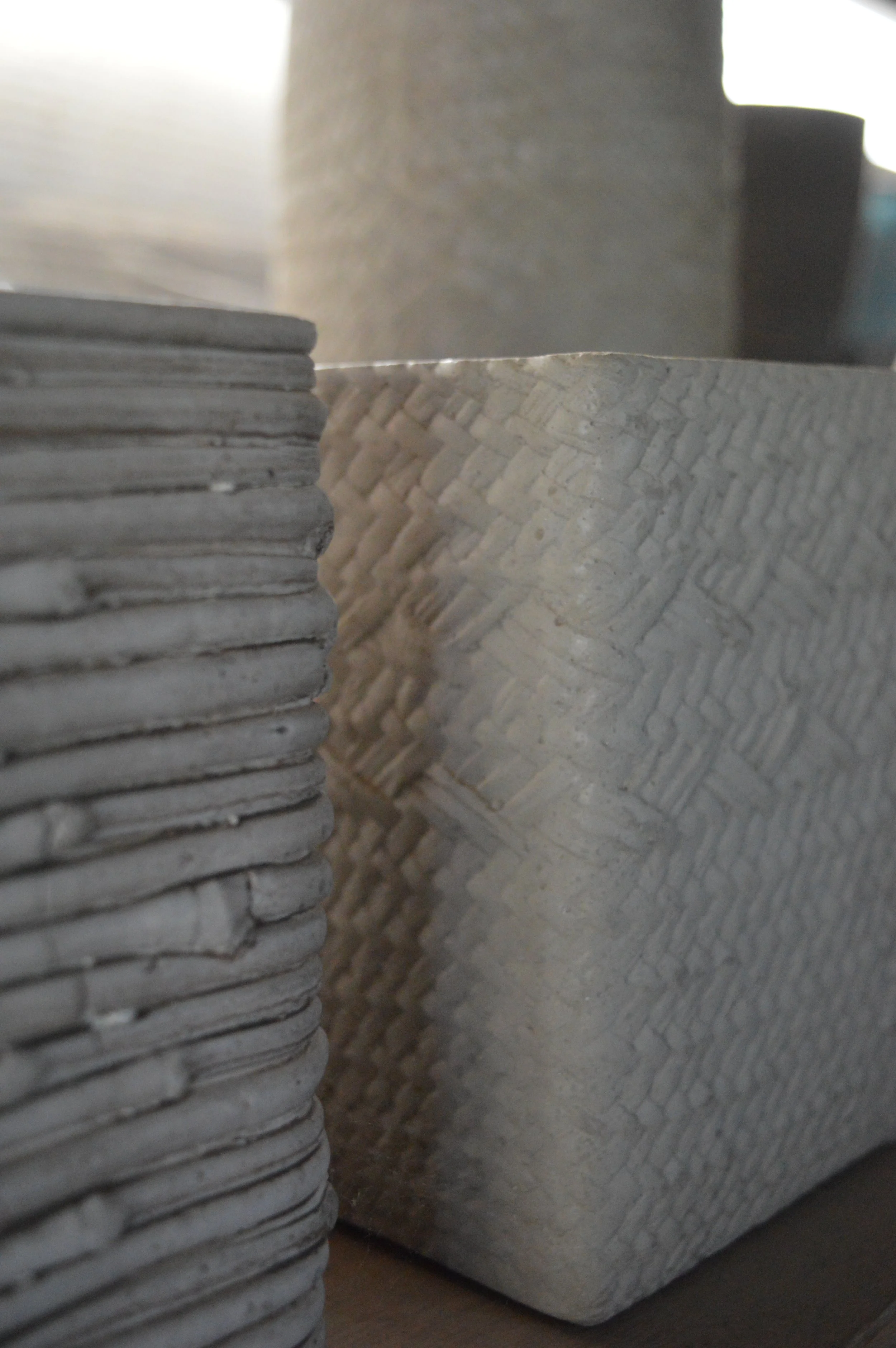 Close-up of textured, stacked paper sheets with folds and creases, arranged vertically and horizontally.