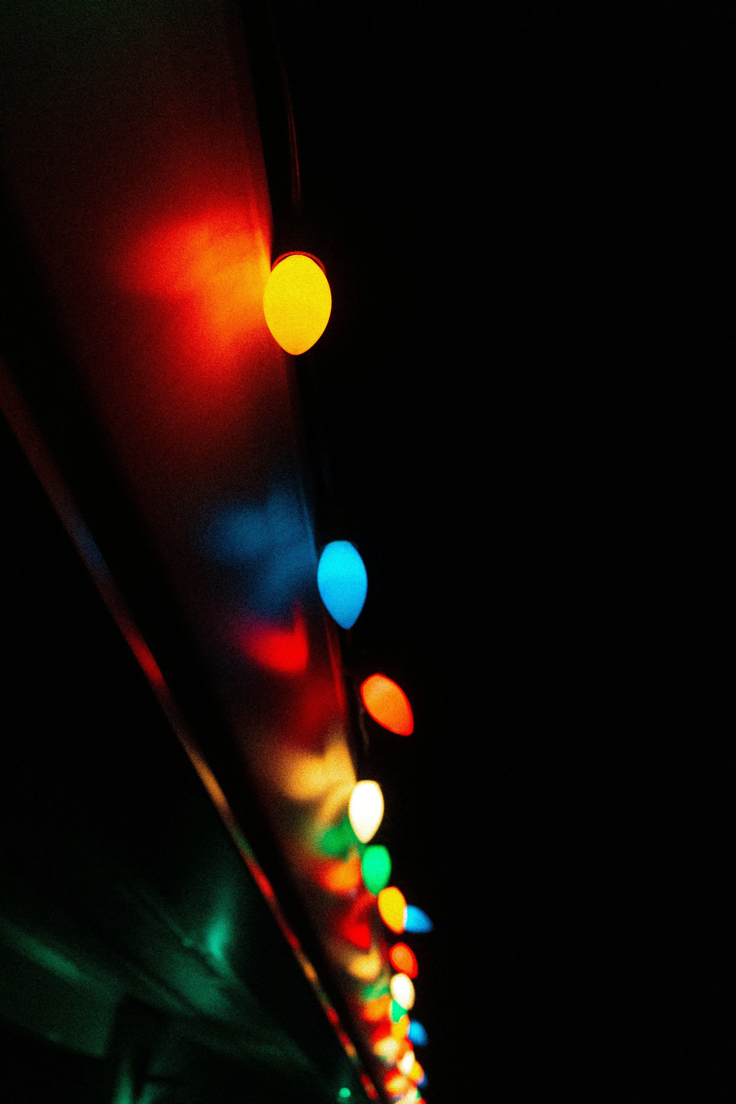 A series of colorful lights, including red, yellow, blue, and green, are lined up against a black background, creating a bright and vibrant display.