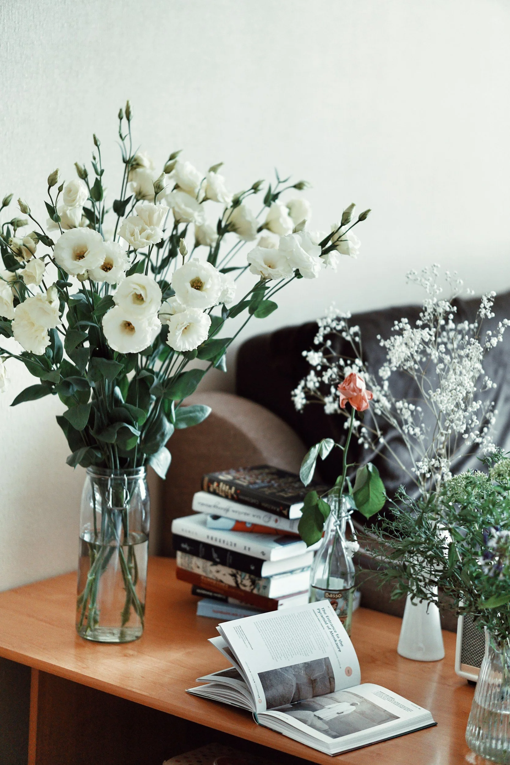 White flowers, books, and greenery in a warm consulting workspace.