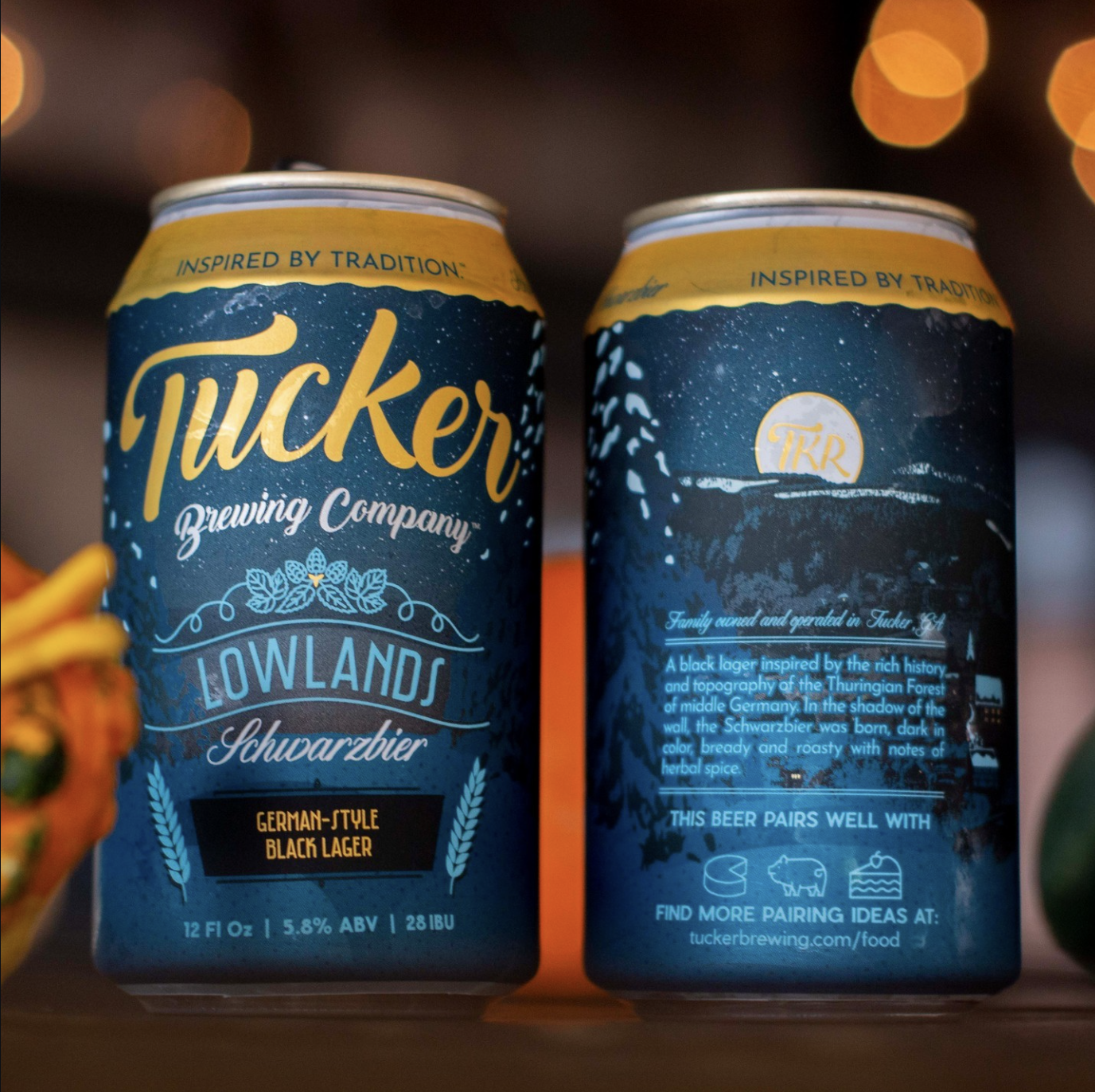 Two cans of Schwarzbier German-style black lager with a blue and yellow label featuring the brand name, a moon image, and detailed description.