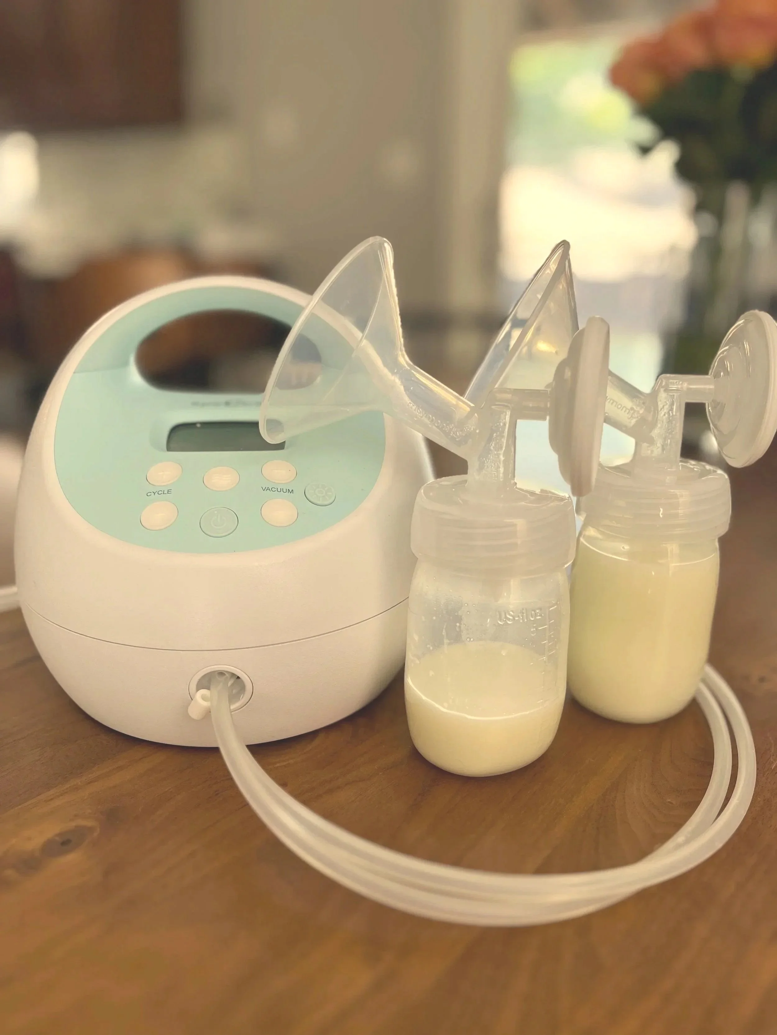Breast milk pump with two bottles filled with milk.