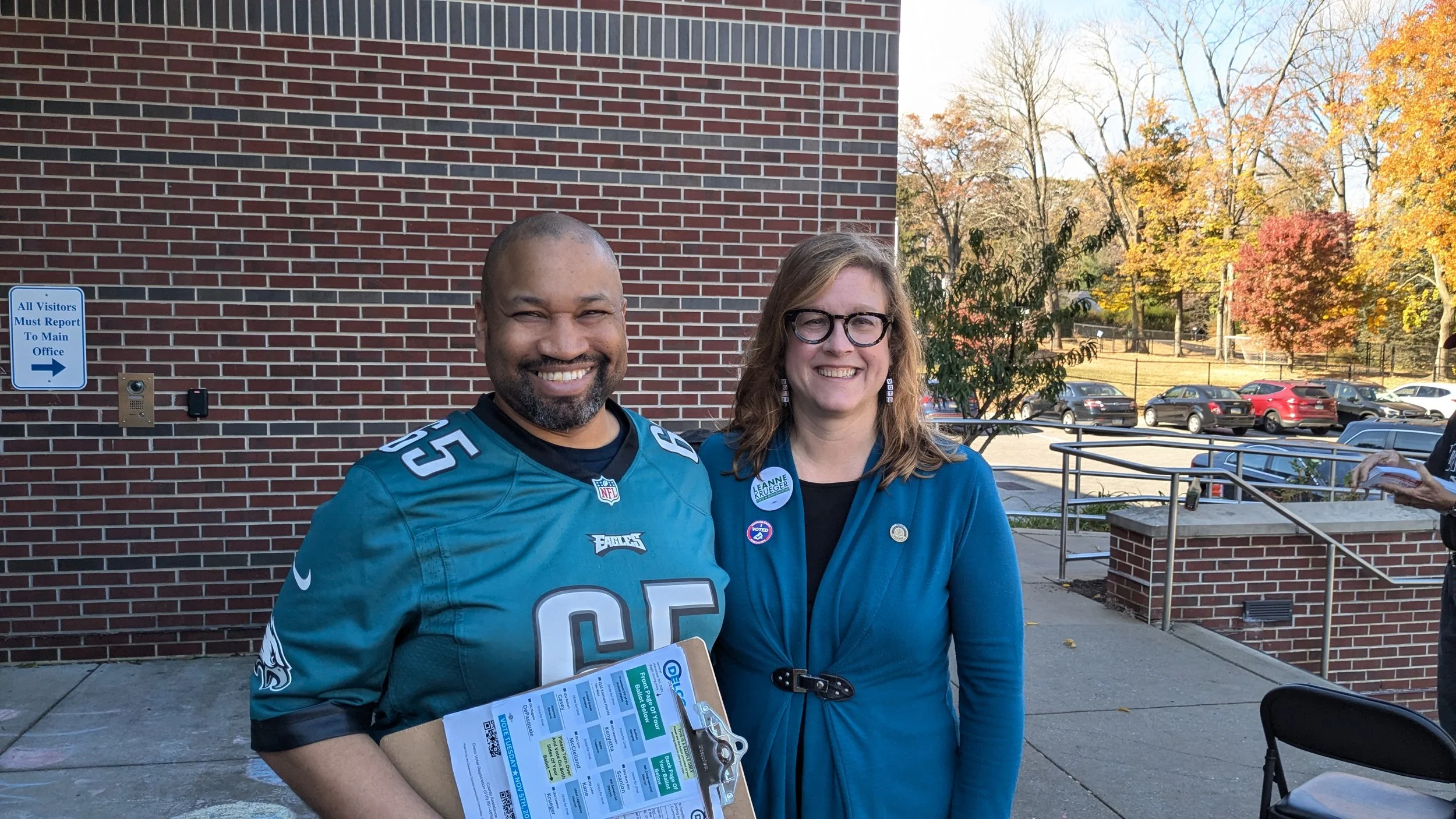 Two people pose after helping knock doors