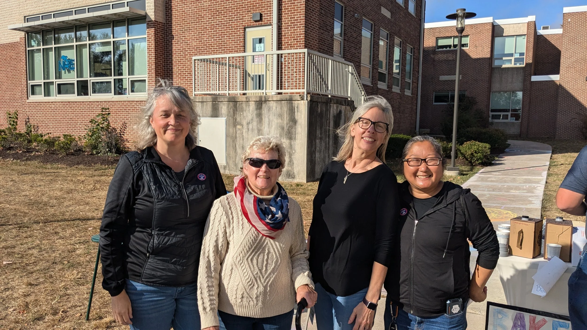 A group of people pose for a picture at the local polling place after helping staff the polls