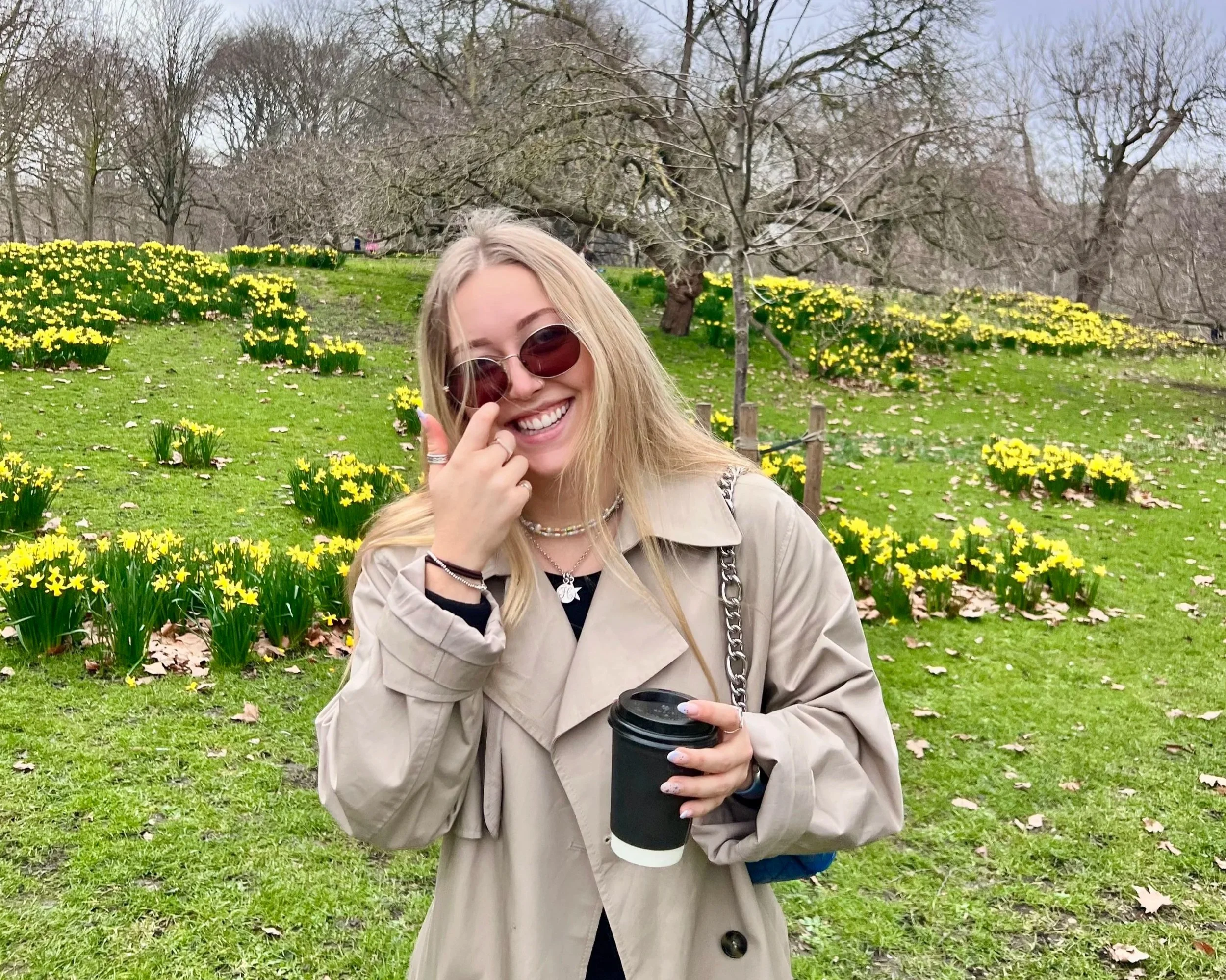 Hannah Rye, founder of AUTON Marketing, standing outdoors among daffodils.