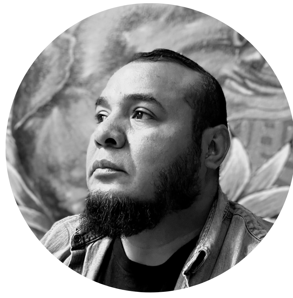 Retrato en blanco y negro de un hombre con barba y cabello corto, mirando hacia la izquierda, con un fondo artístico.