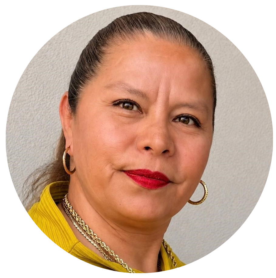 Retrato de una mujer de cabello peinado hacia atrás, usando aretes de aro, collar dorado y vestido amarillo, con fondo neutro