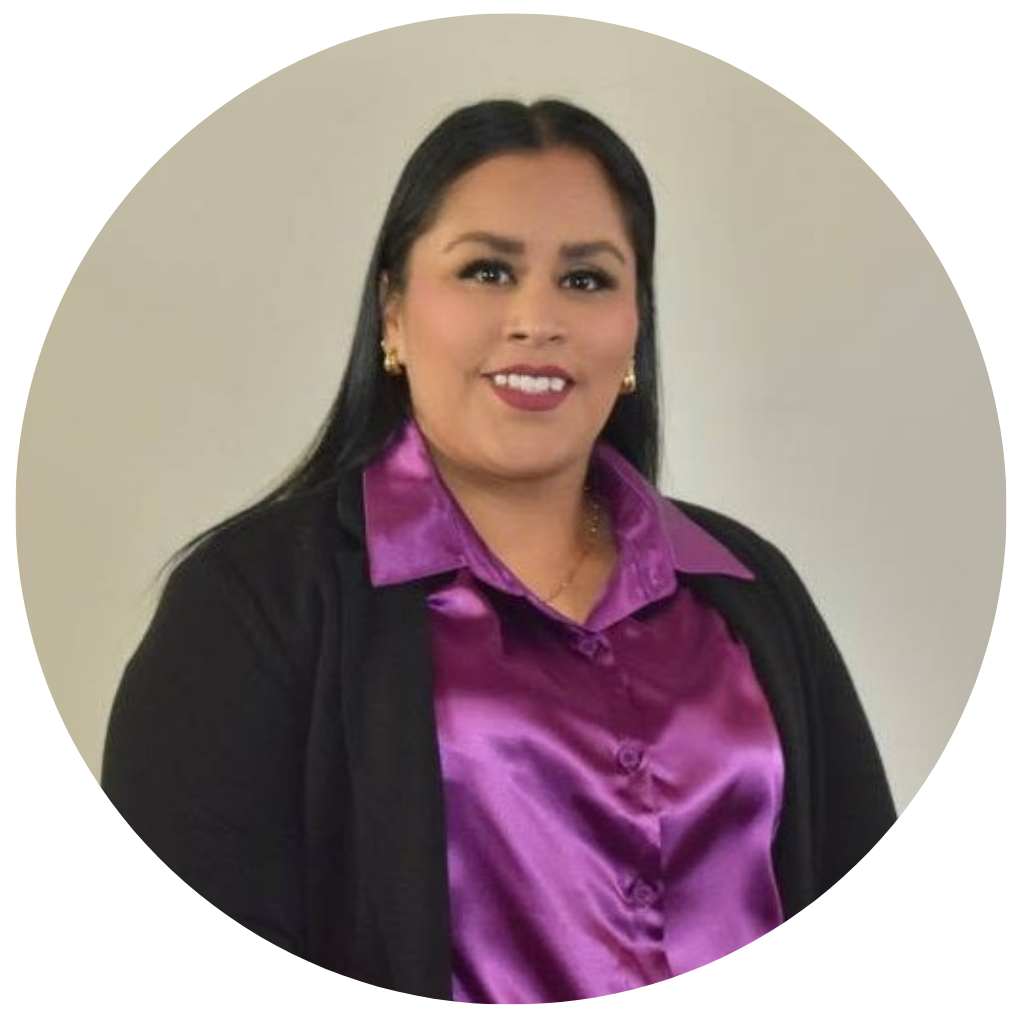 Retrato de una mujer sonriendo, lleva blusa morada de seda y chaqueta negra, con pendientes dorados.