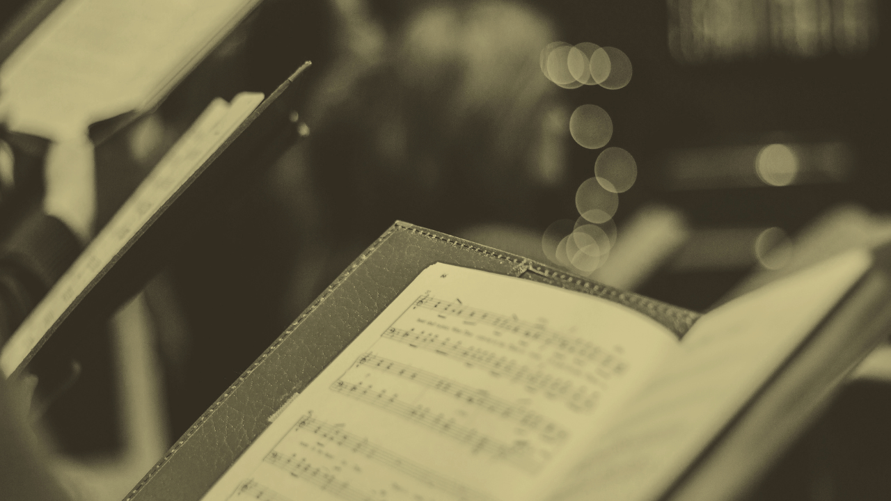 An open sheet music book on a music stand.