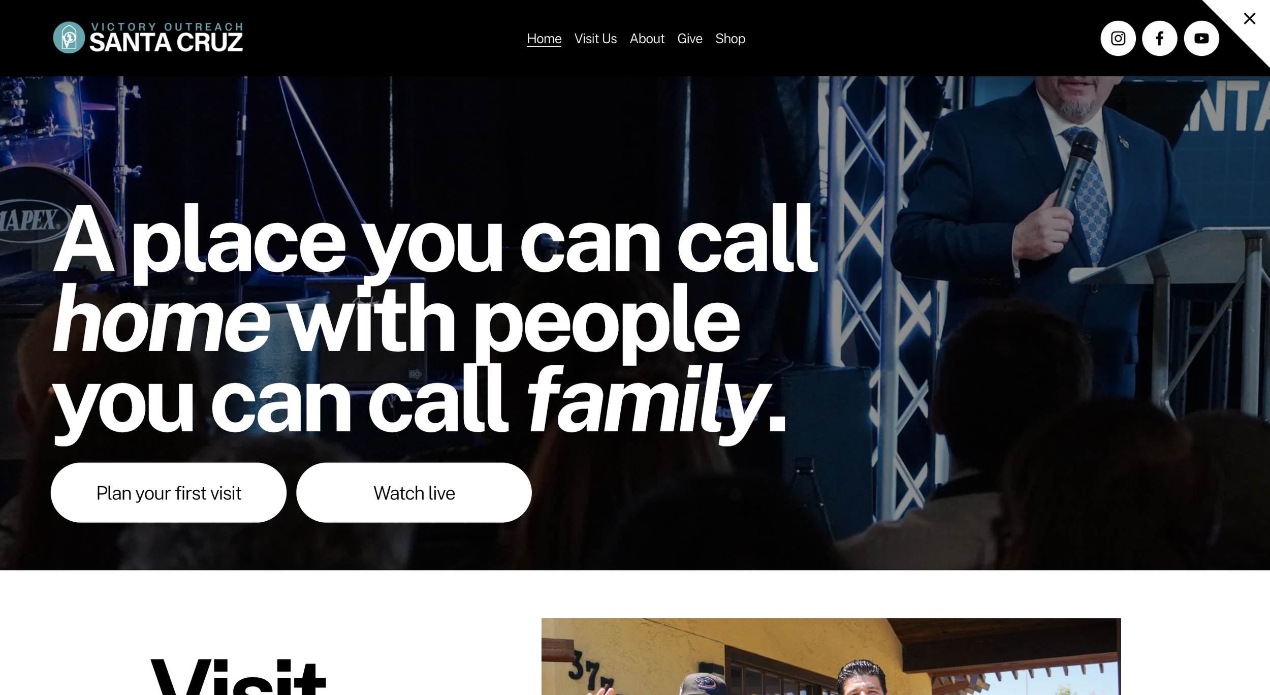 Screenshot of Victory Outreach Santa Cruz website homepage featuring a man in a suit speaking at a podium, with stage lights and musical instruments in the background.