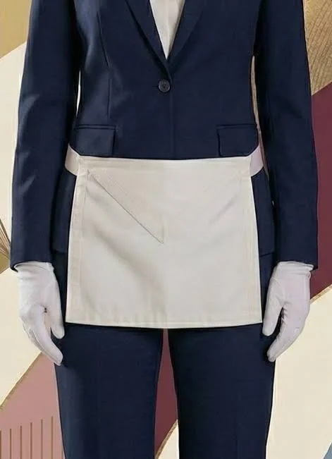 Personne portant un uniforme à manches longues avec une veste bleue, un tablier blanc, et des gants blancs. Vêture d'un Apprenti franc-maçon
