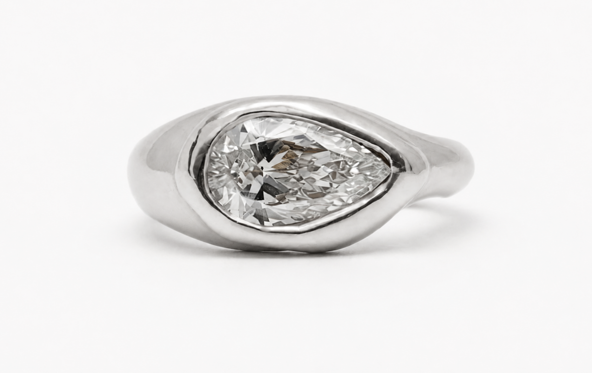 18k white gold ring with pear-cut lab-grown diamond in an organic bezel setting.