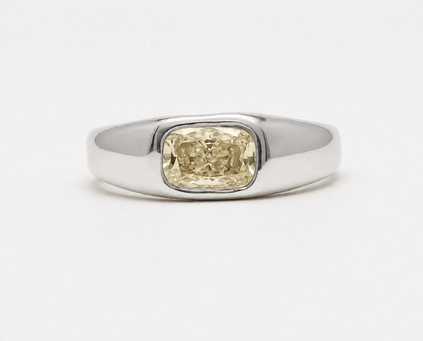 Organic 18k white gold ring with pale yellow elongated cushion-cut lab-grown diamond in a bezel setting.