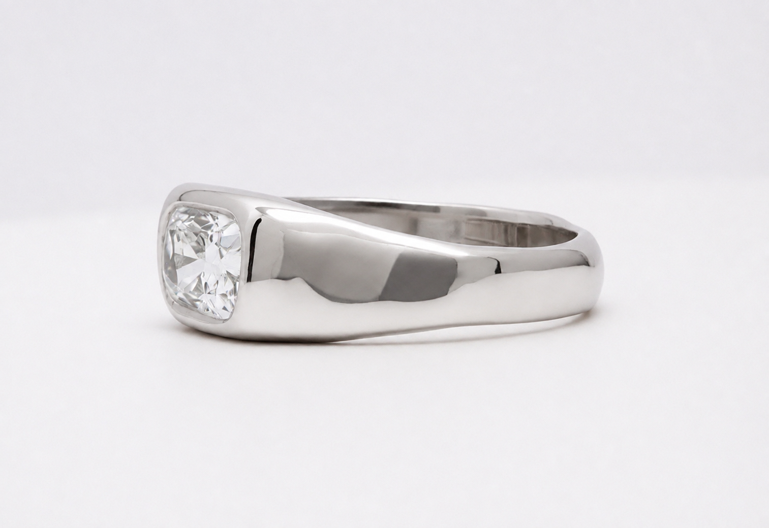 Polished 18k 9k white gold ring with elongated cushion-cut white diamond in an organic bezel setting
