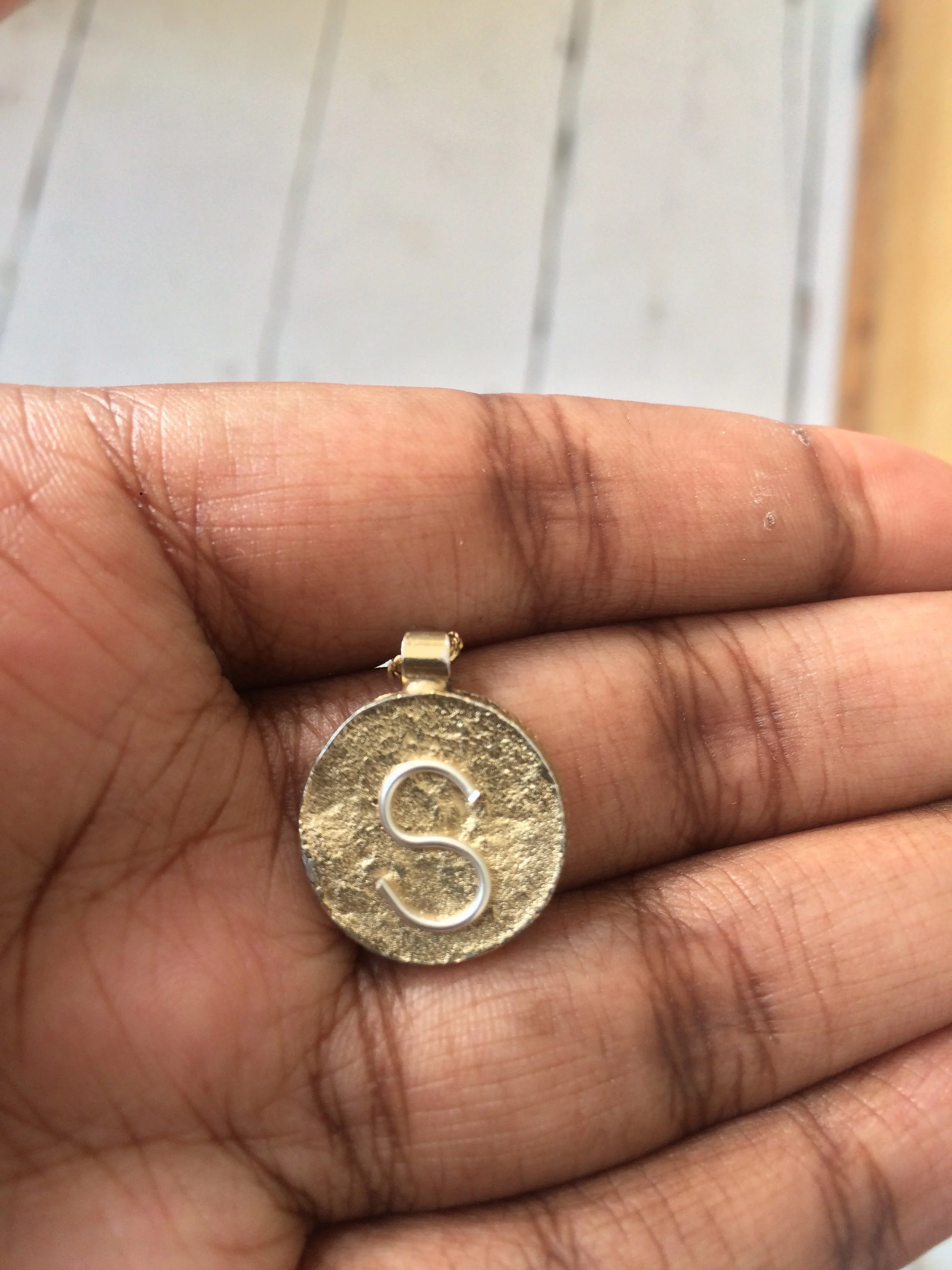 A custom 9k gold S pendant