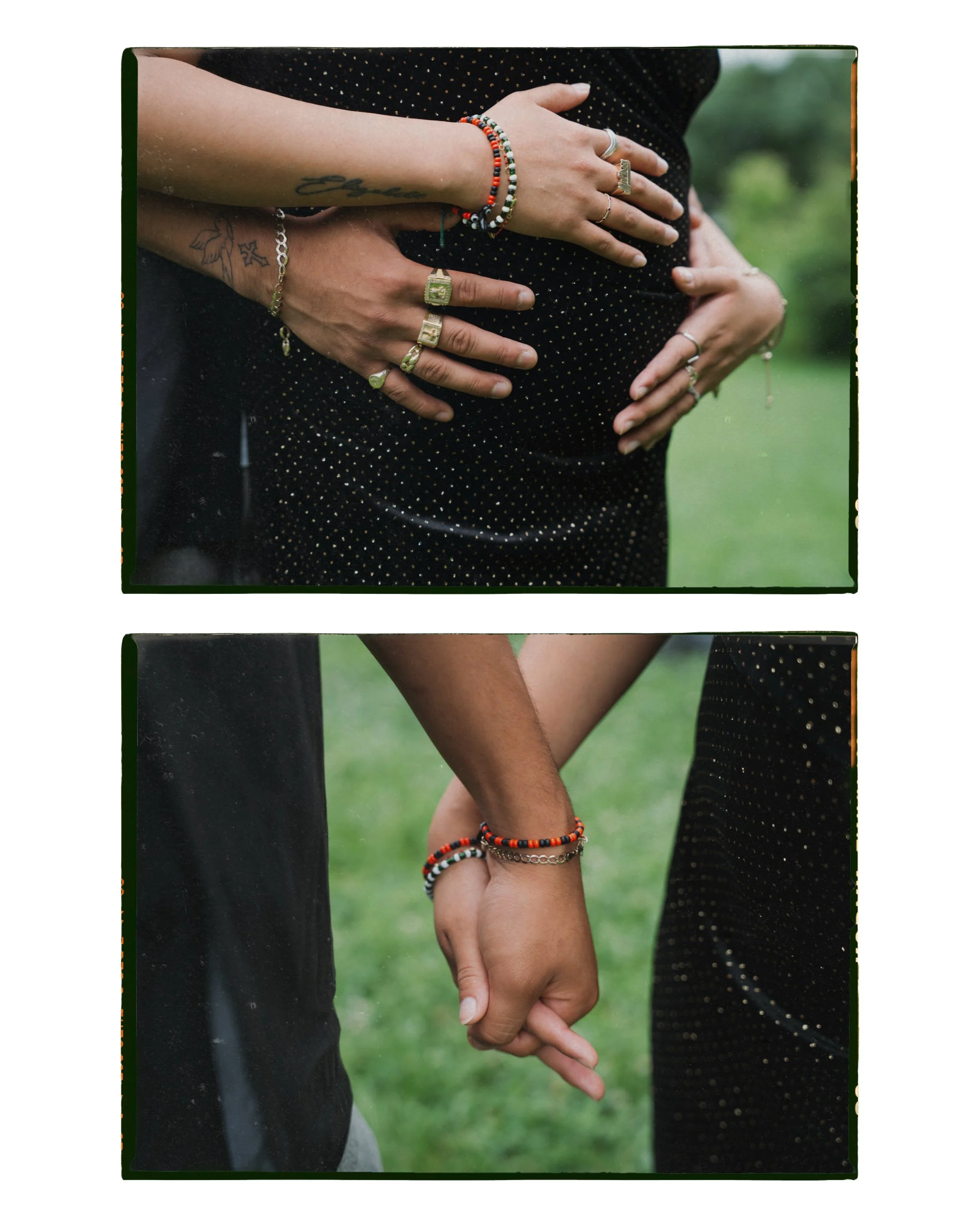 Close-up of two people holding hands outdoors, both wearing multiple jewelry bracelets and rings, with a green natural background.