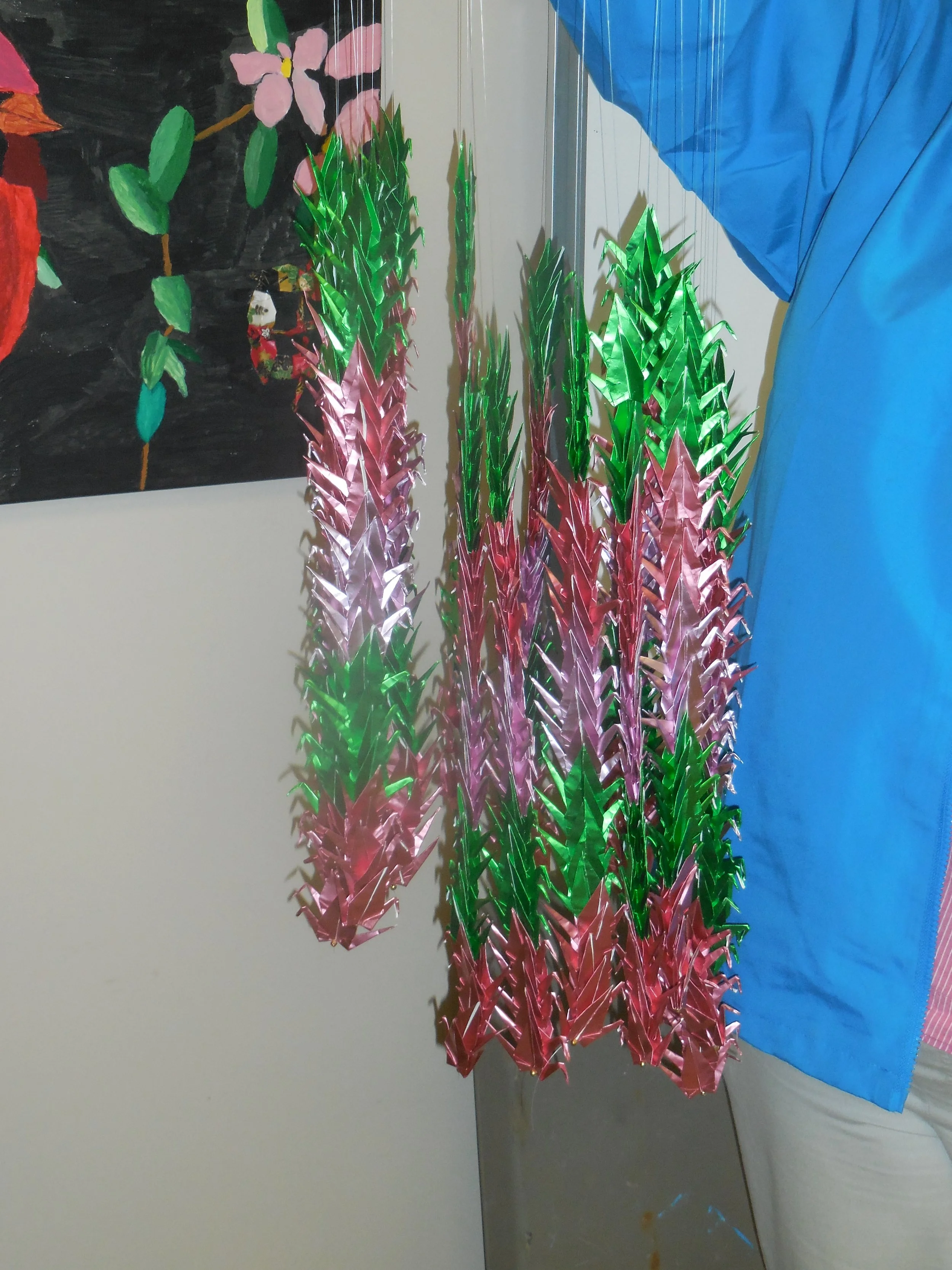 Colorful origami critters from cranes, dragon flies, butterflies, dragons, worry bird boxes, prayer angel boxes, frogs, foil backed creations, and crane mobiles as you see here.