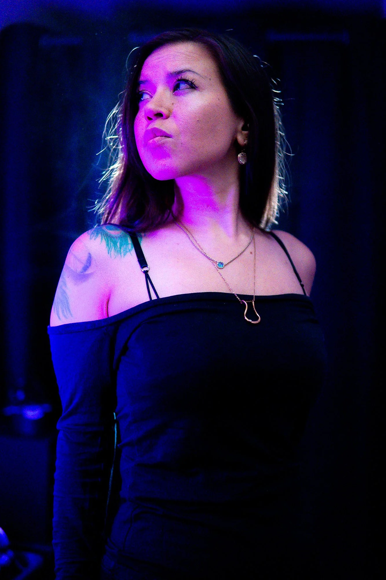 Portrait of the Commandess in violet stage light, looking upward in profile