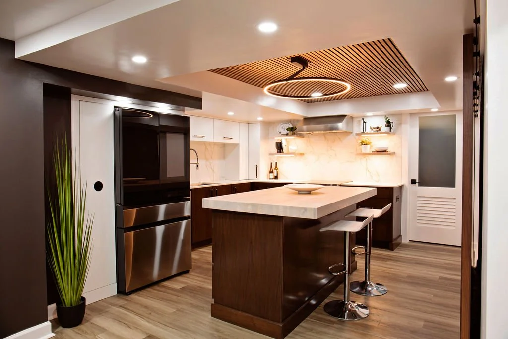 Renovated basement.  Updated to include kitchen with custom stained wood and white cabinetry, Dekton backsplash and countertop, food-grade butcher block island, open shelving, and wood slat ceiling.