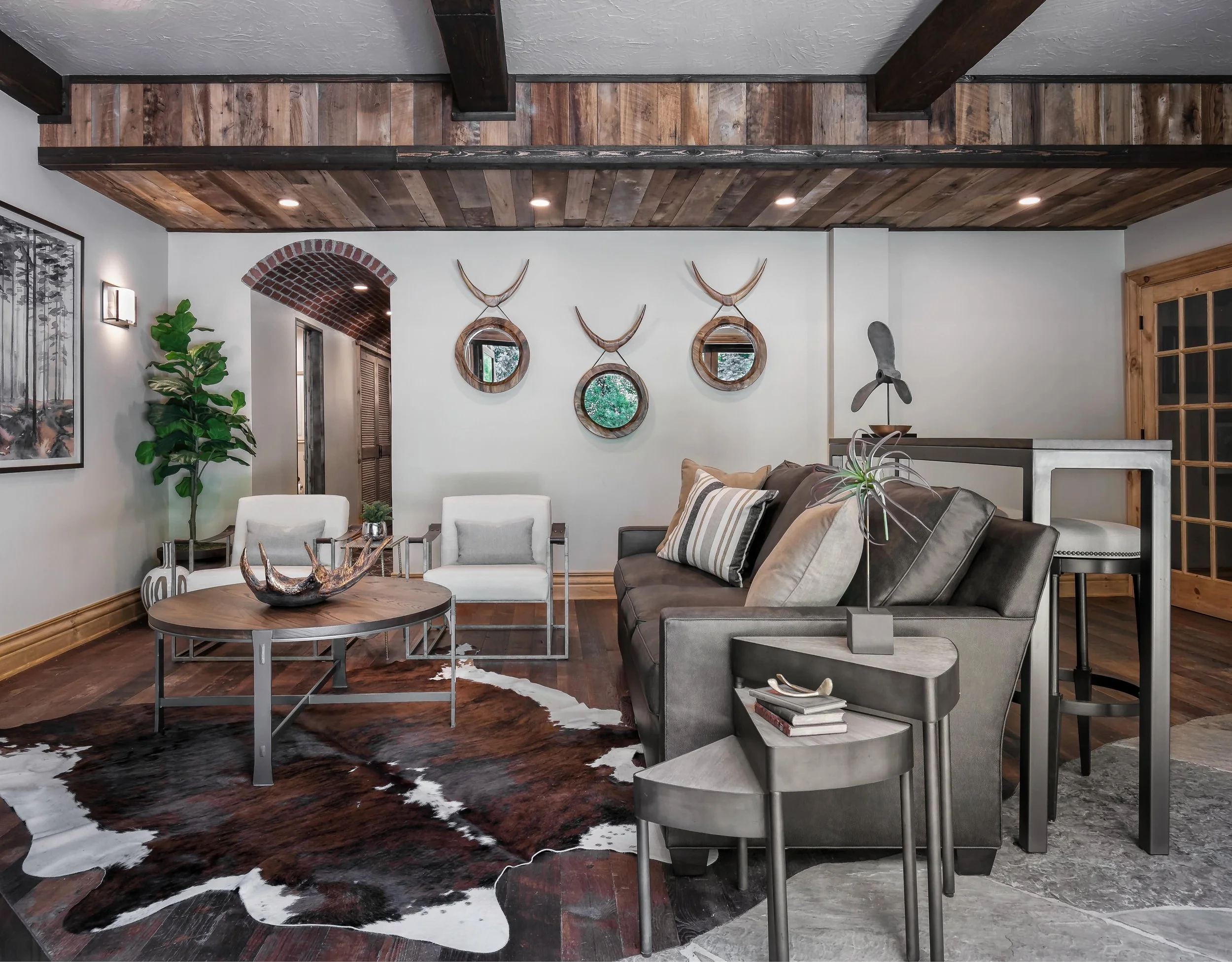 Warm basement lounge with architectural wood detailing, layered seating, and rustic-modern character