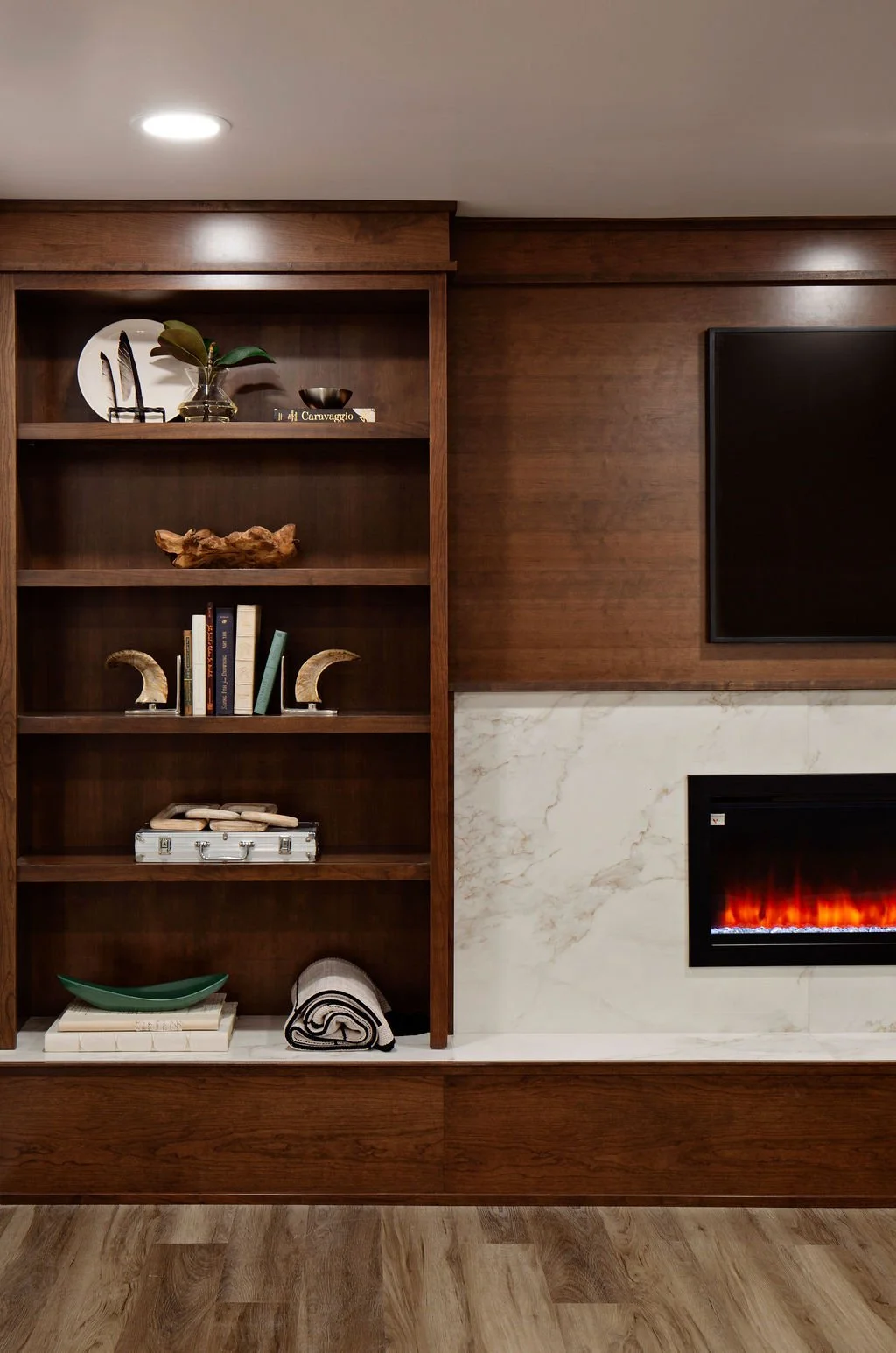 Custom media wall with integrated wood shelving, linear fireplace, and contemporary architectural detailing