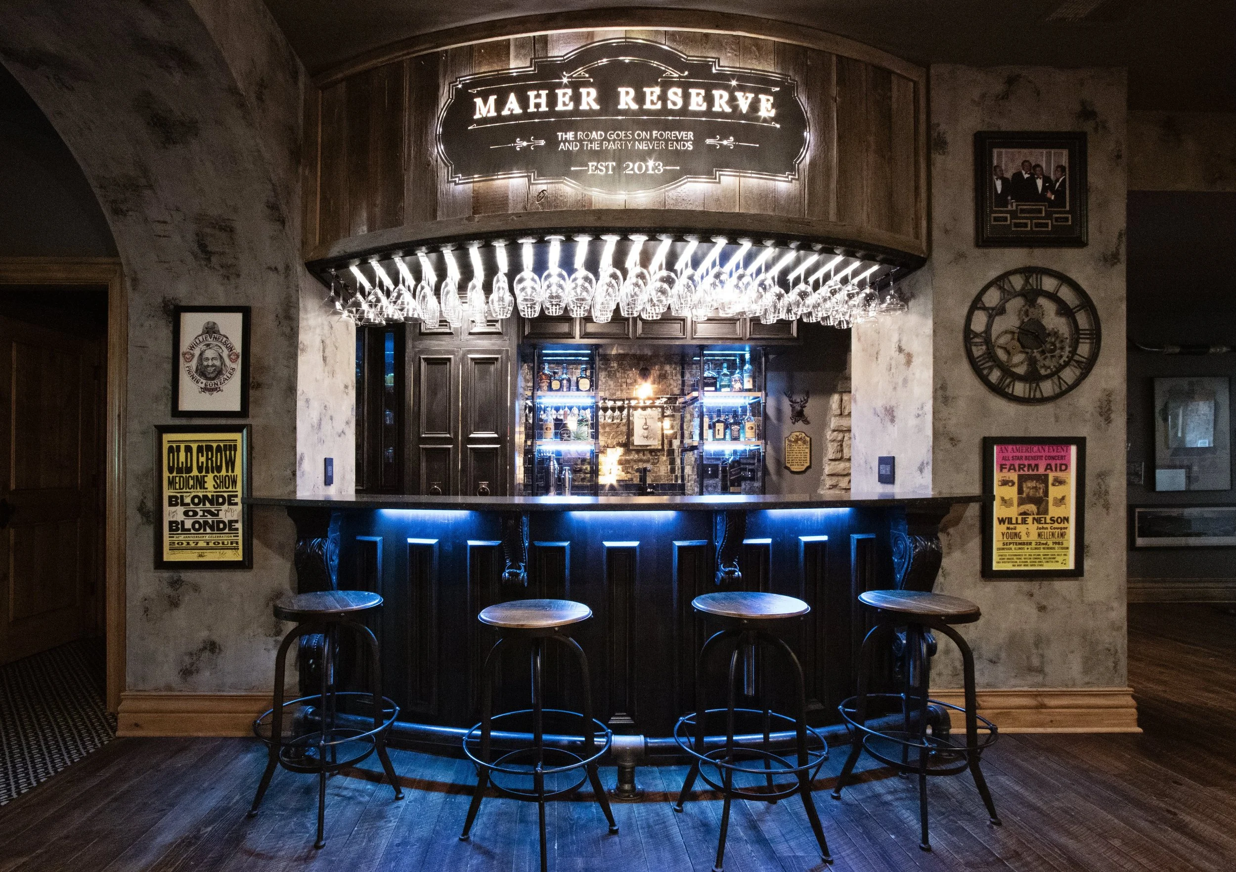 Custom home bar with dramatic lighting, reclaimed wood detailing, and vintage-inspired entertaining atmosphere