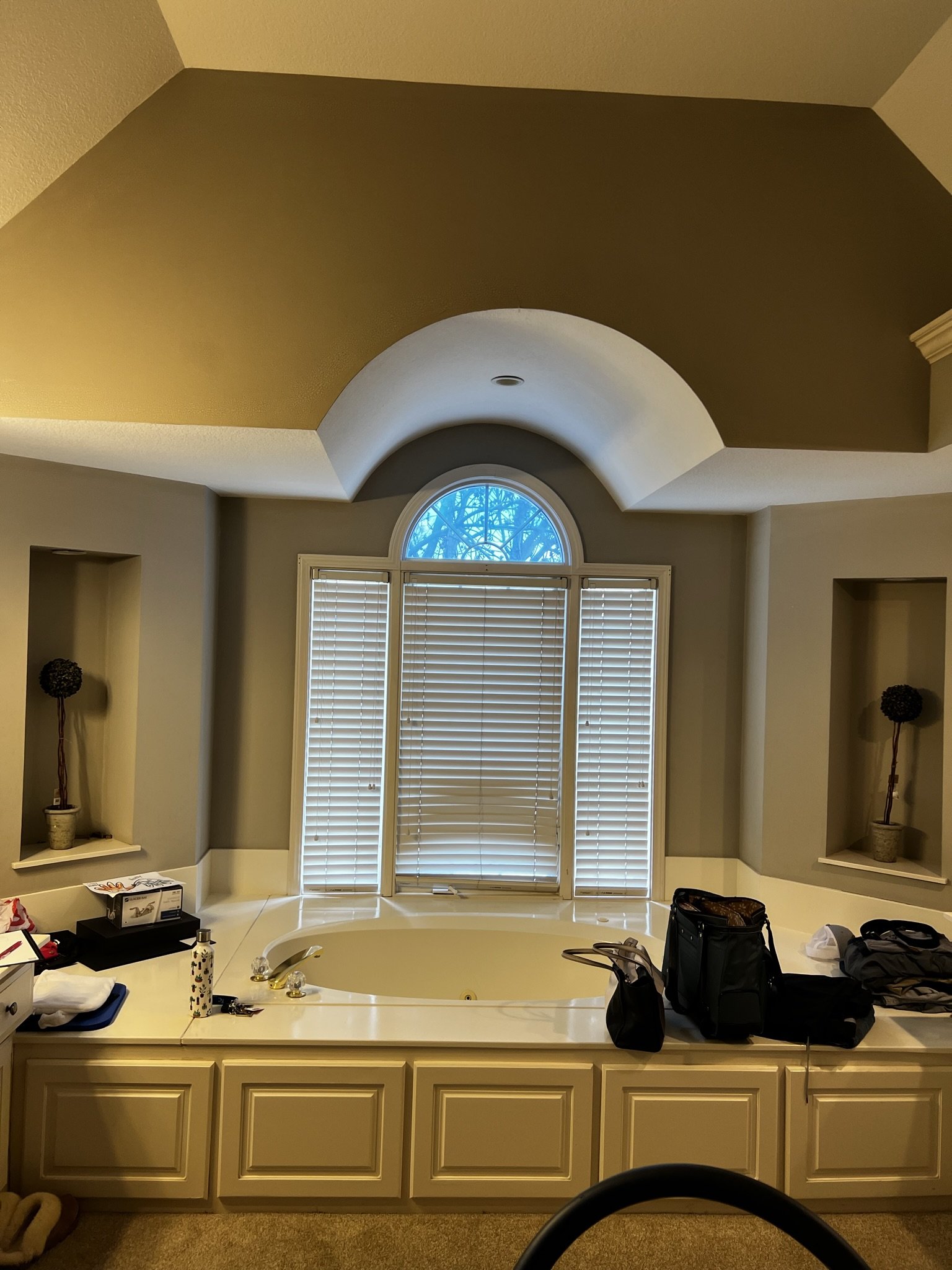 Before photo: outdated whirlpool tub with arched window in dated primary bathroom, Overland Park KS