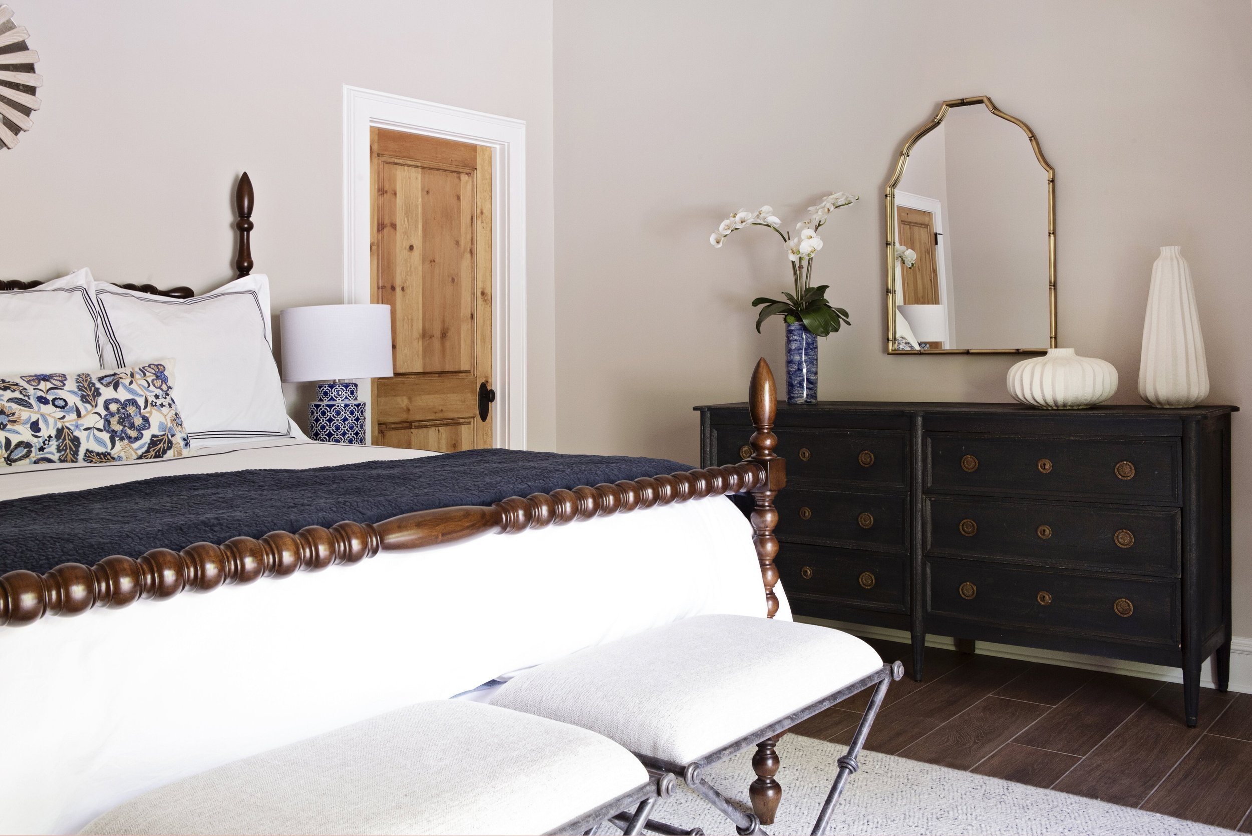 View from the guest bedroom into the ensuite bath, with black dresser and vintage mirror, Overland Park, Kansas.