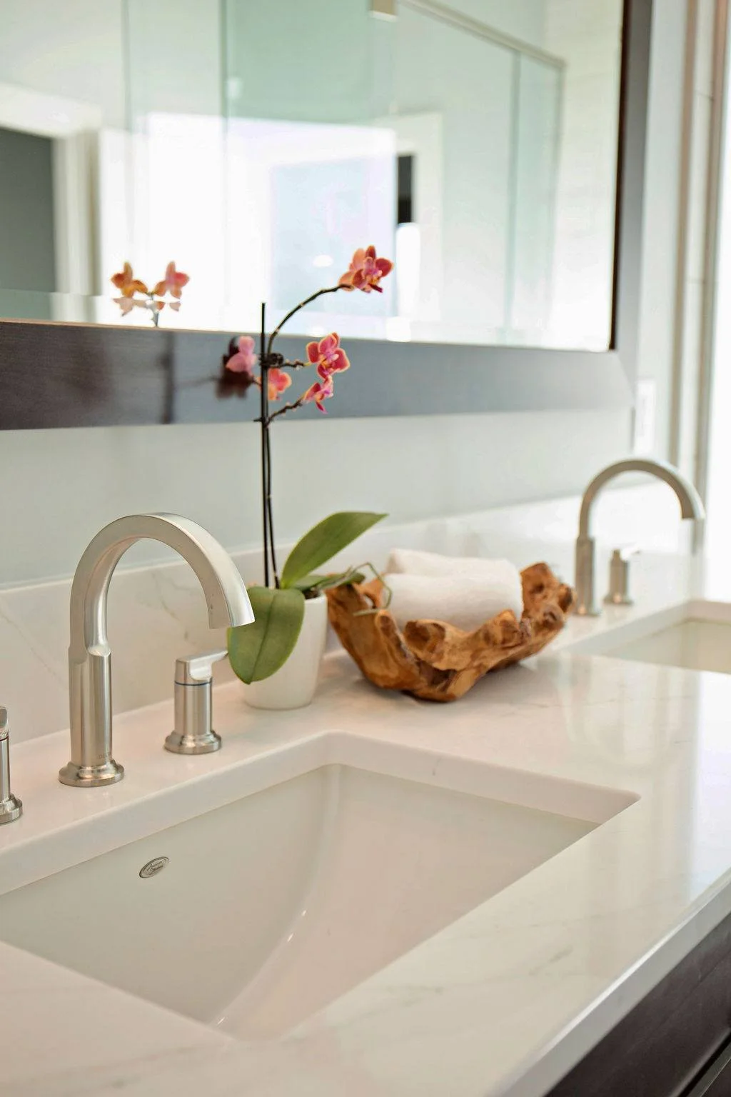 Sink detail with brushed nickel faucet, orchid, and teak towel bowl in Pleasant Hill MO primary bathroom renovation