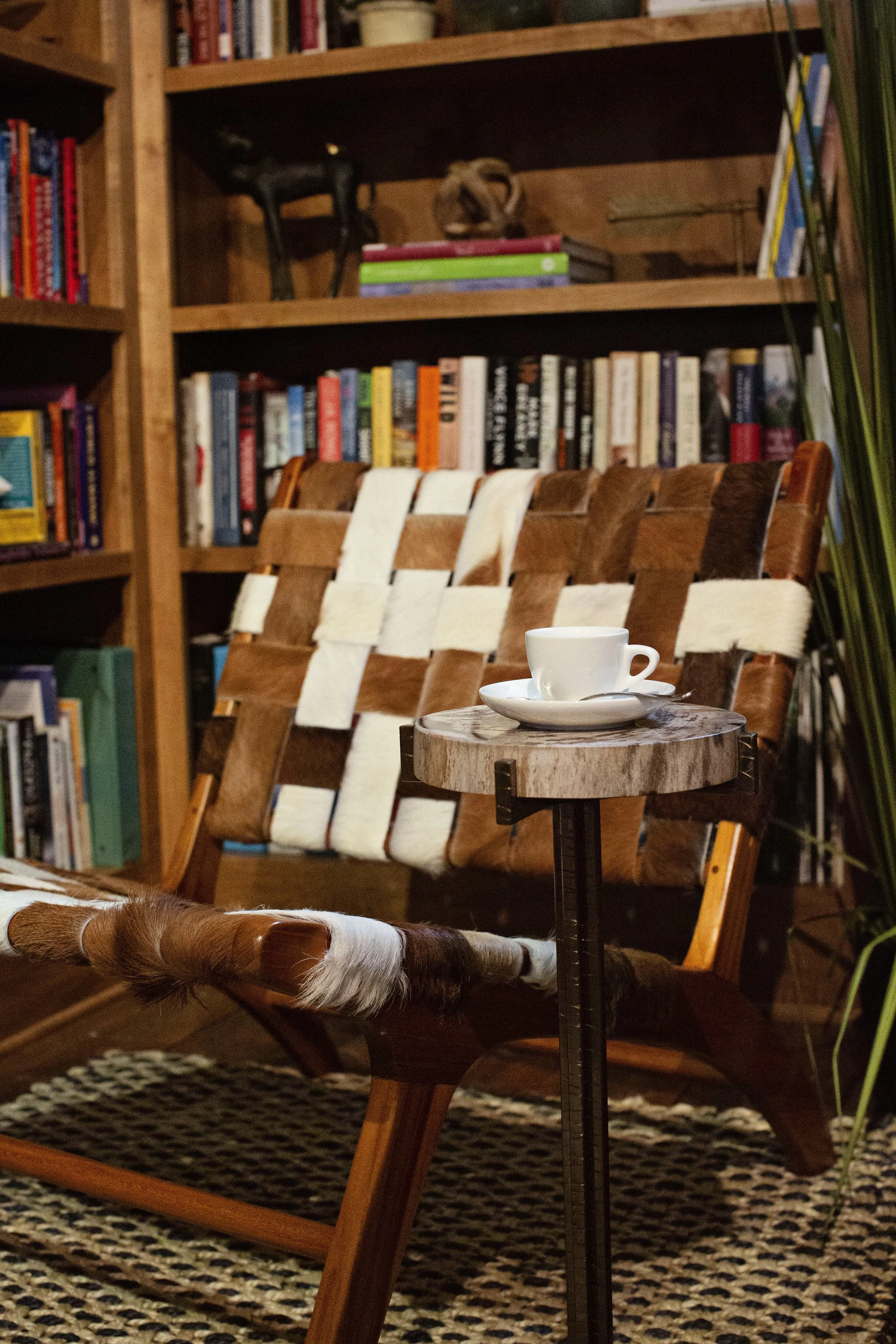 Built-in bookshelf with woven cowhide reading chair and rustic side table
