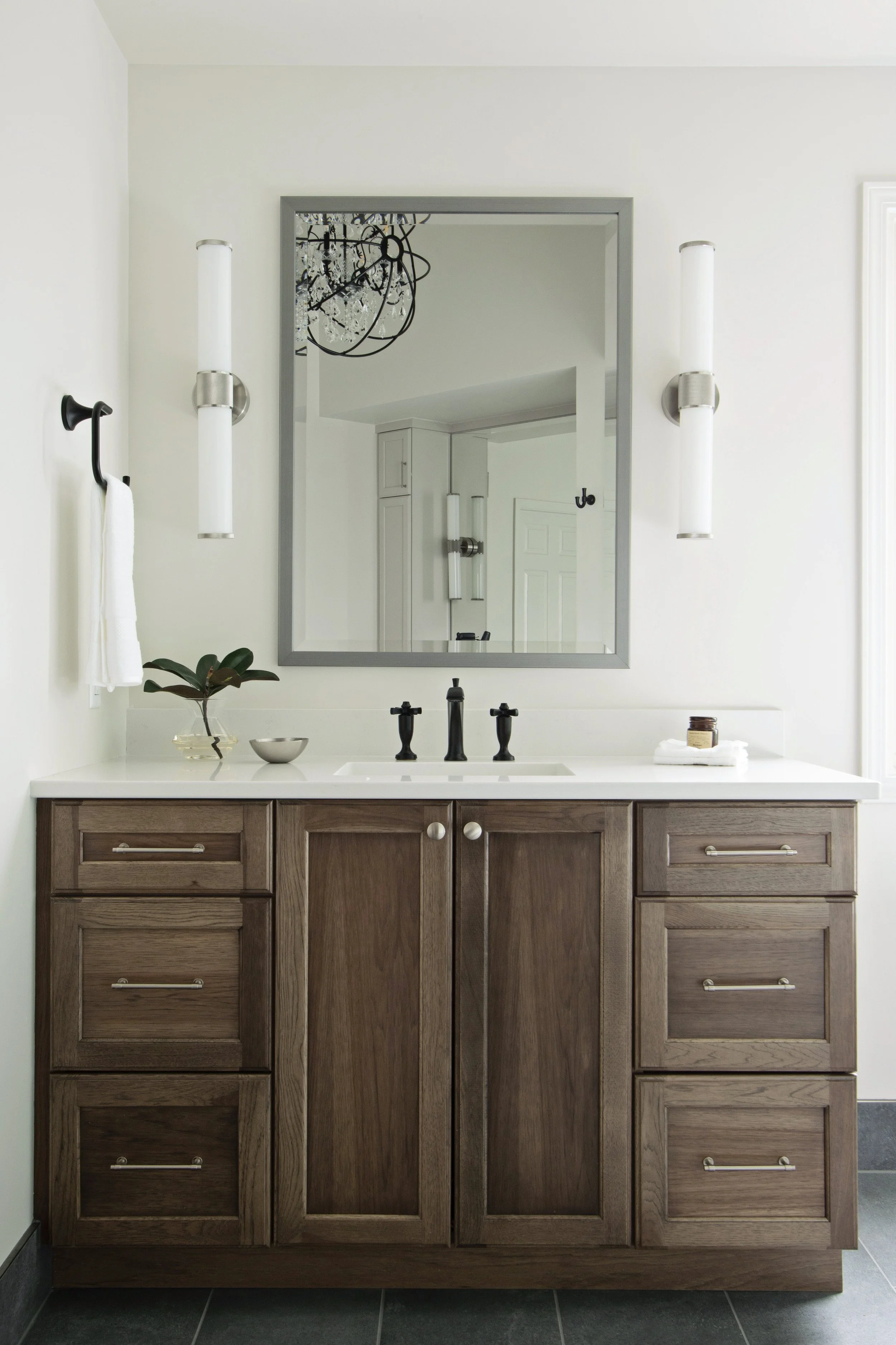 primary bathroom with custom vanity, quartz countertops, and modern wall sconces Kansas City