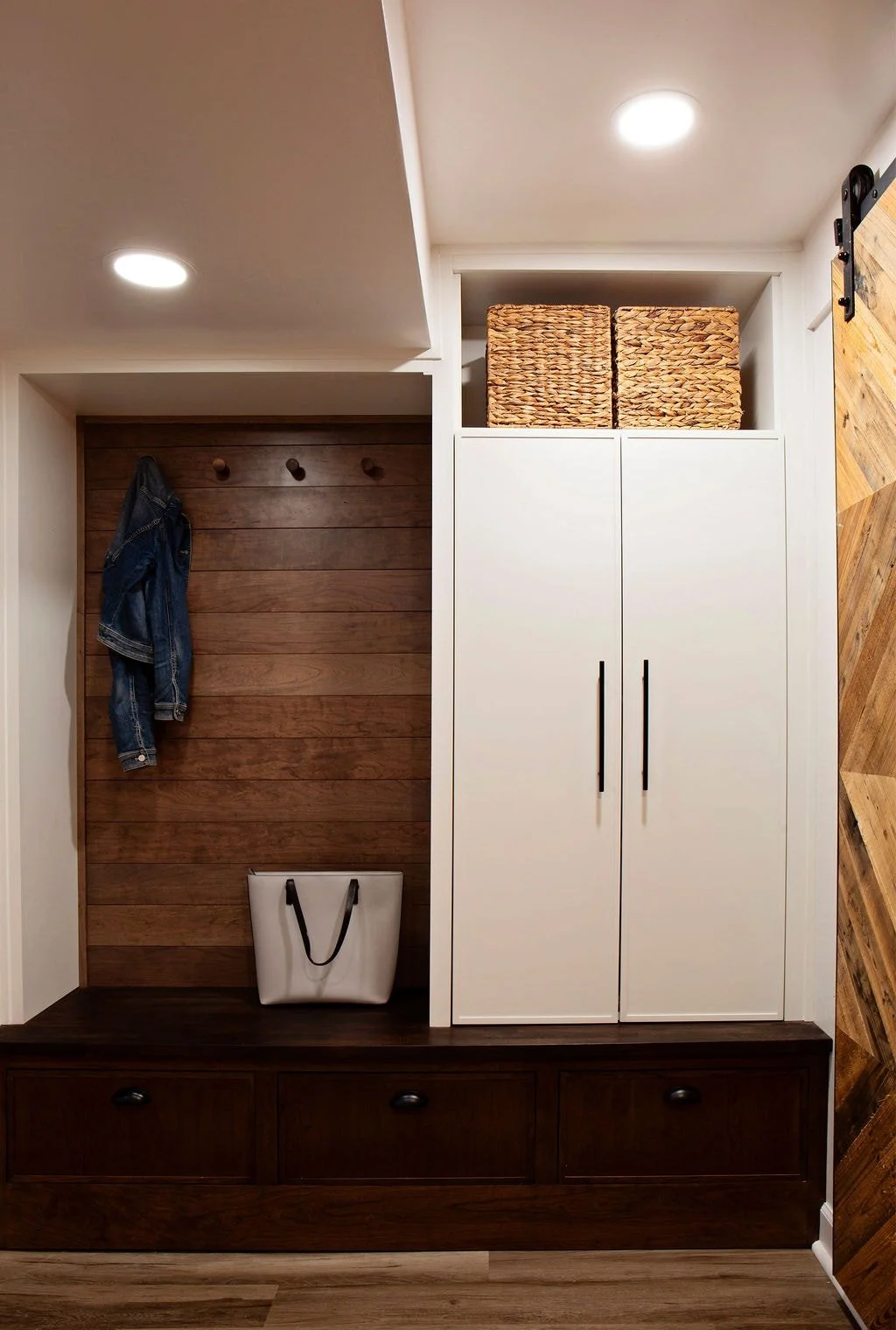 Mudroom and entryway renovation with custom storage, sliding barn door, and built-in cabinetry