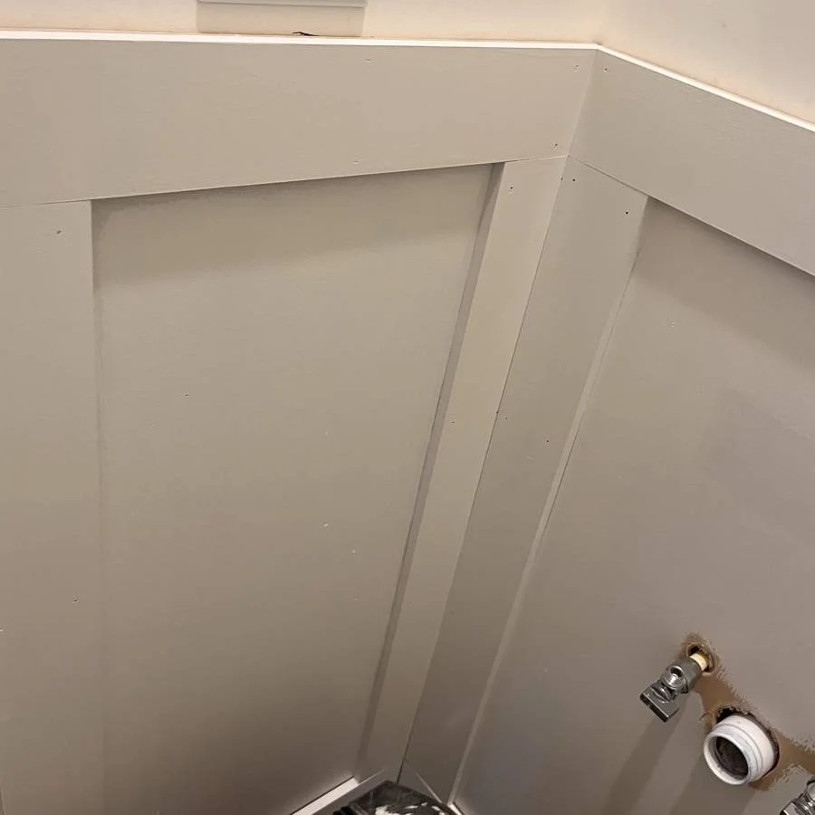 During: patterned wallpaper and wainscoting are in place while finish work continues.