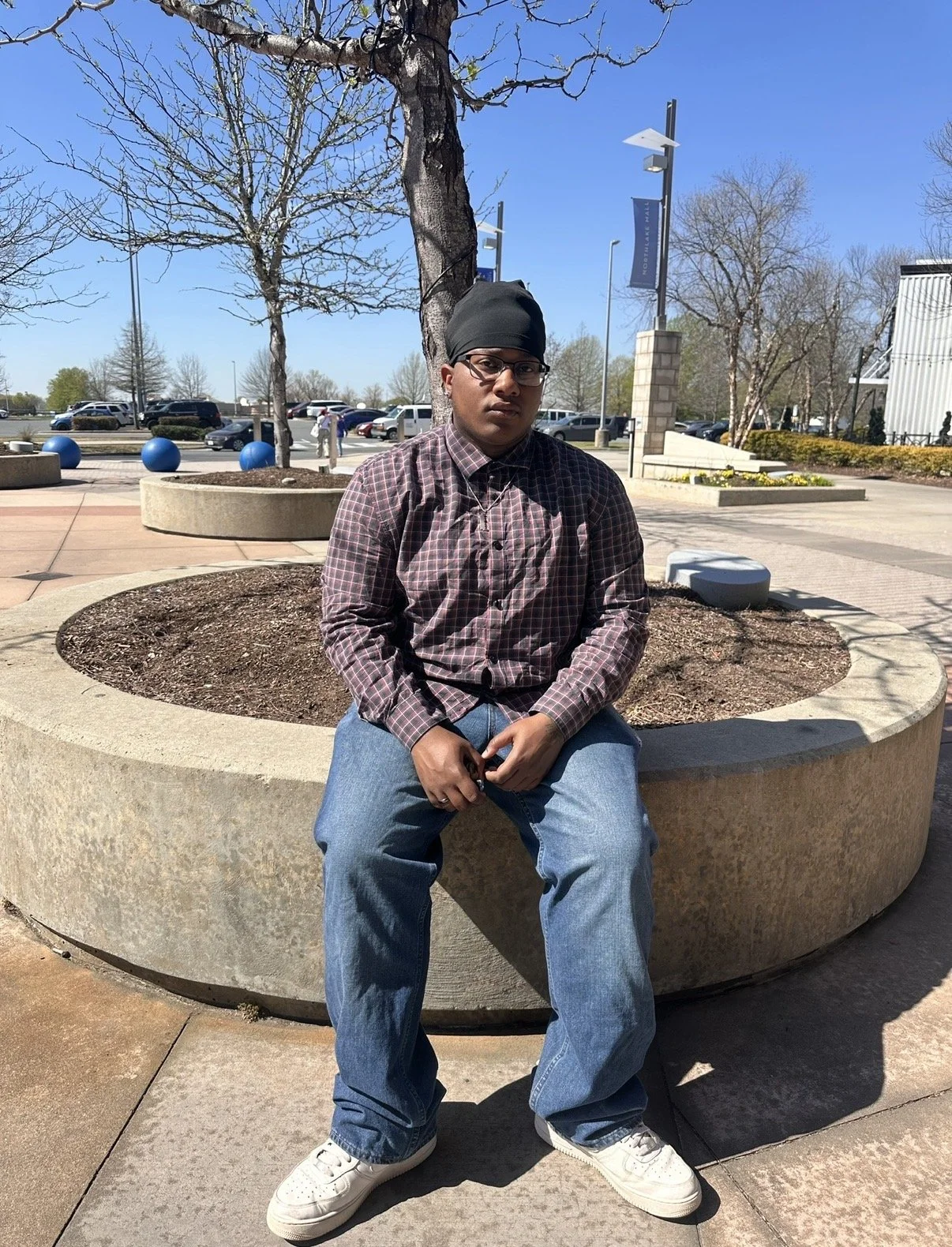 Xufflex, founder of PsychicHotline, sitting outdoors on a sunny day.