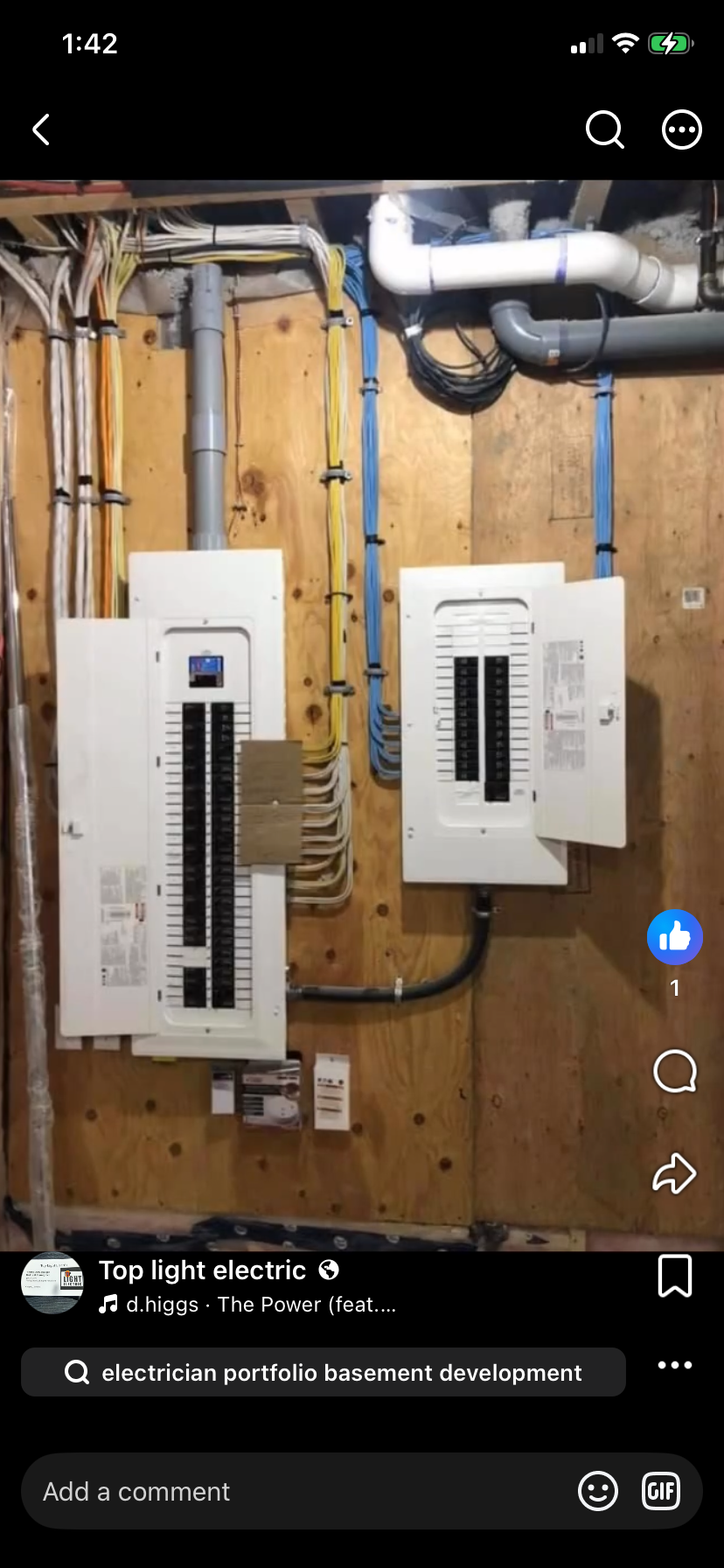 Electrical breaker panels and wiring installed on a wooden wall in a basement.