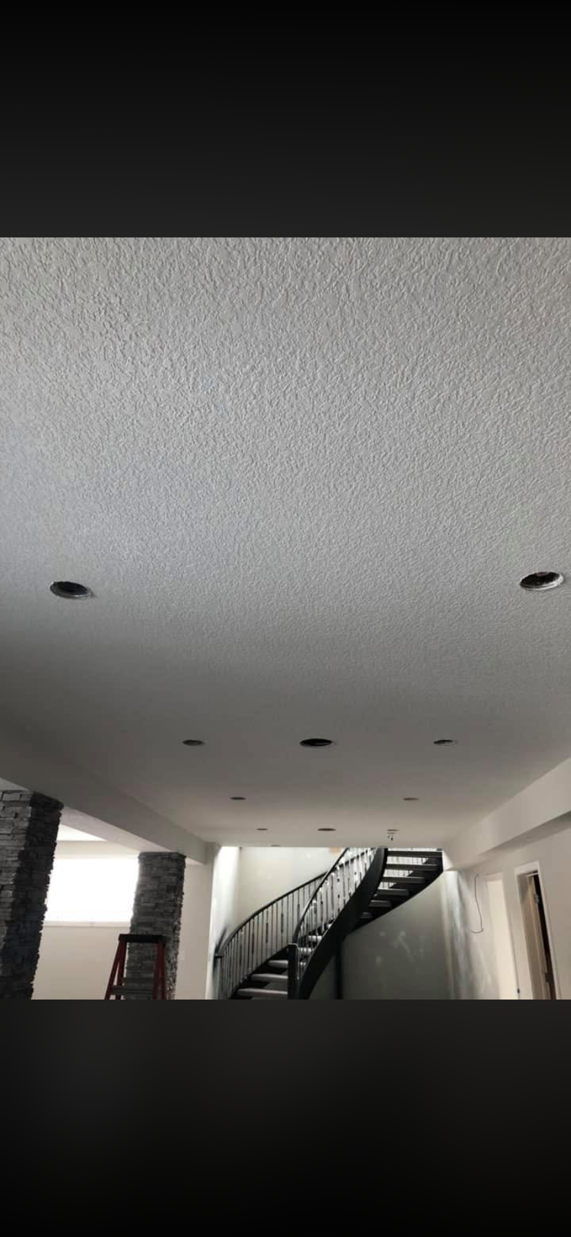 Ceiling with multiple recessed lights in a room under construction.