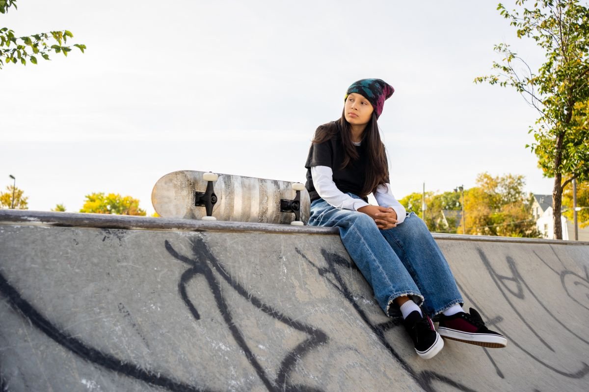 An Electronic Press Kit EPK film still from the Winnipeg short film Plaansh a roo, showcasing a character sitting with a skateboard at a concrete skatepark, captured by a unit stills photographer.