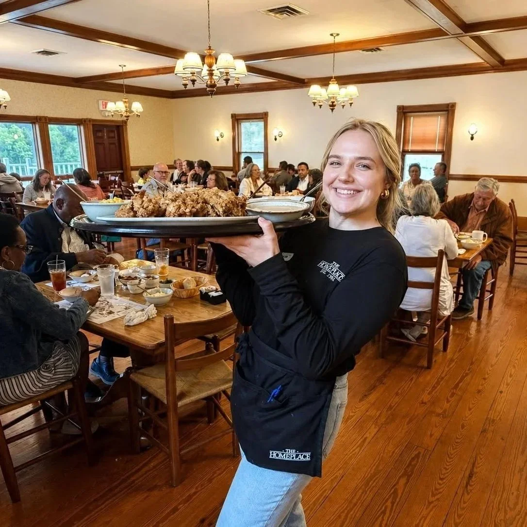 The Homeplace Restaurant team member serving fried chicken to guests in the dining room.