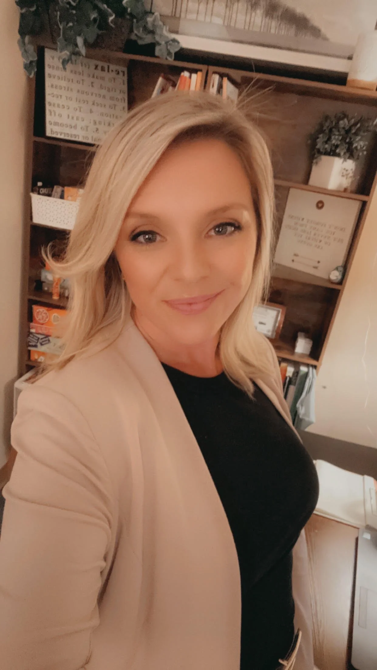 Therapist at Ember & Rise Therapy Group smiling in an indoor office setting.