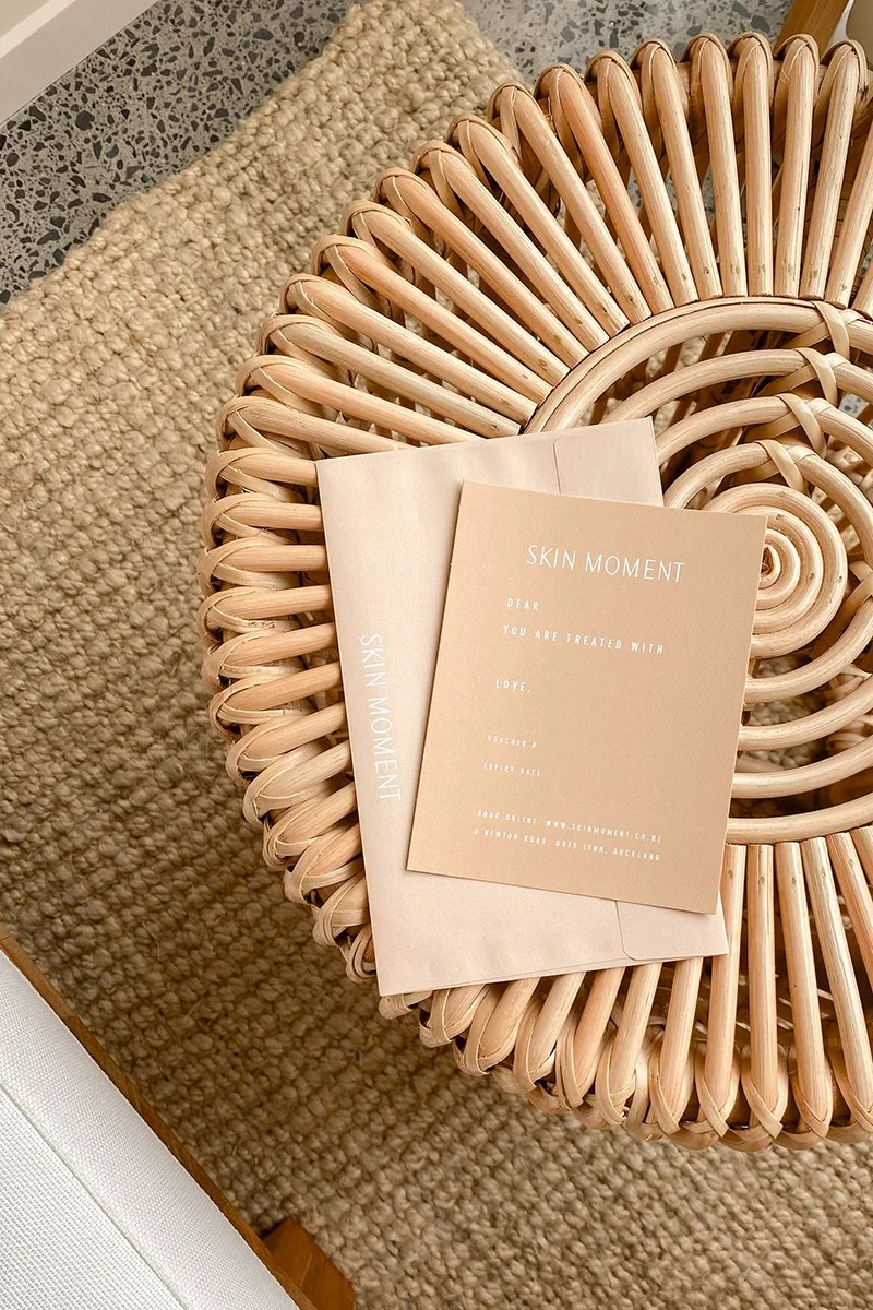 A gift voucher from Skin Moment over a trendy coffee table.