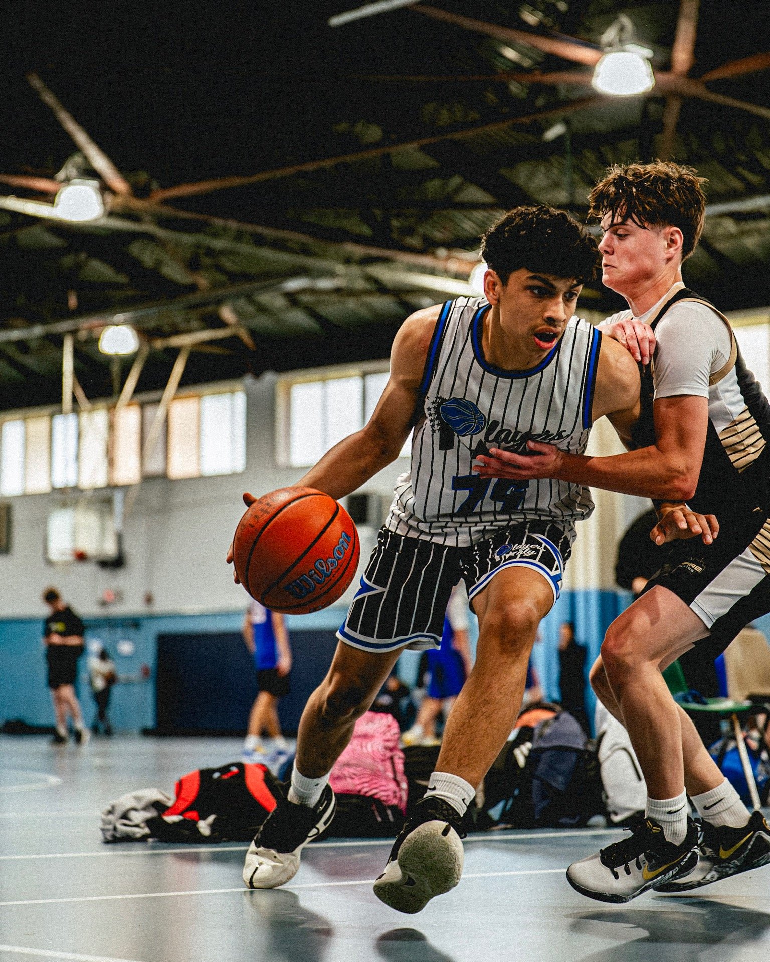 Players Only AAU basketball player driving during game action.