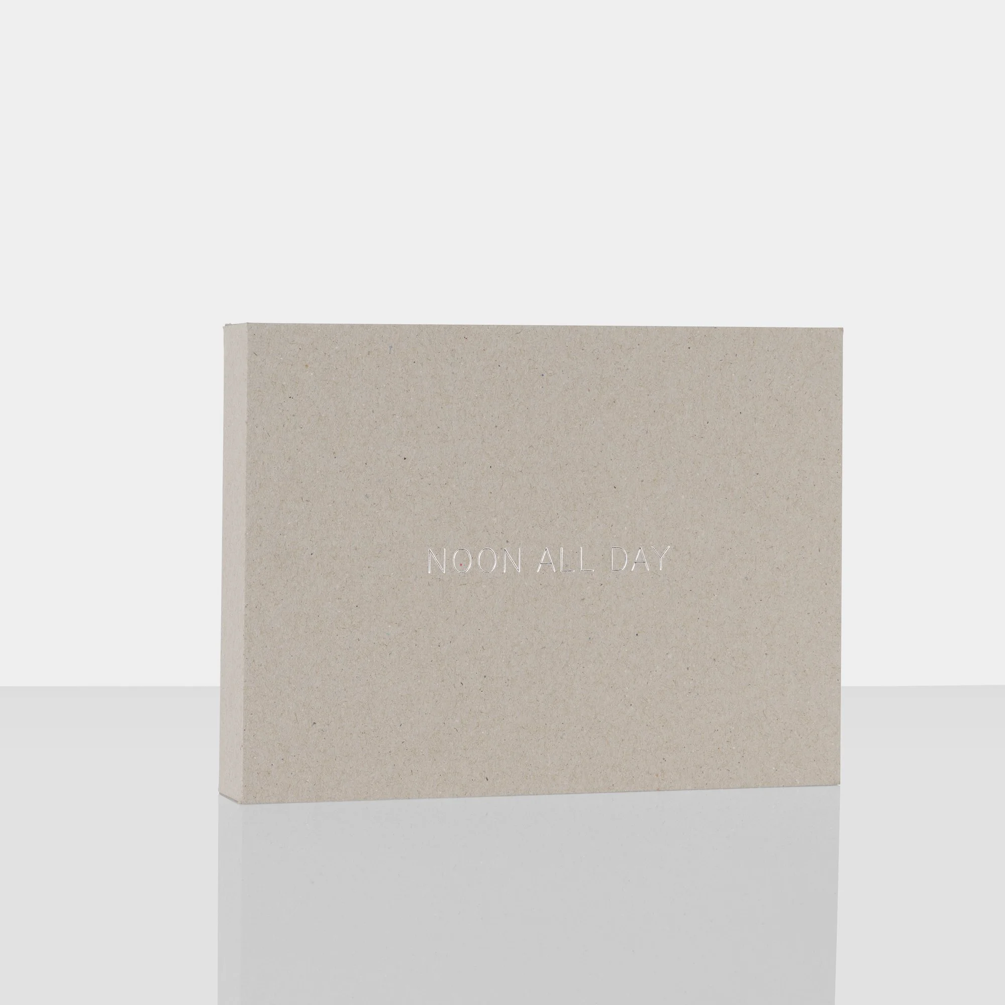 Een kaart met de tekst 'NOON ALL DAY' op een beige achtergrond.