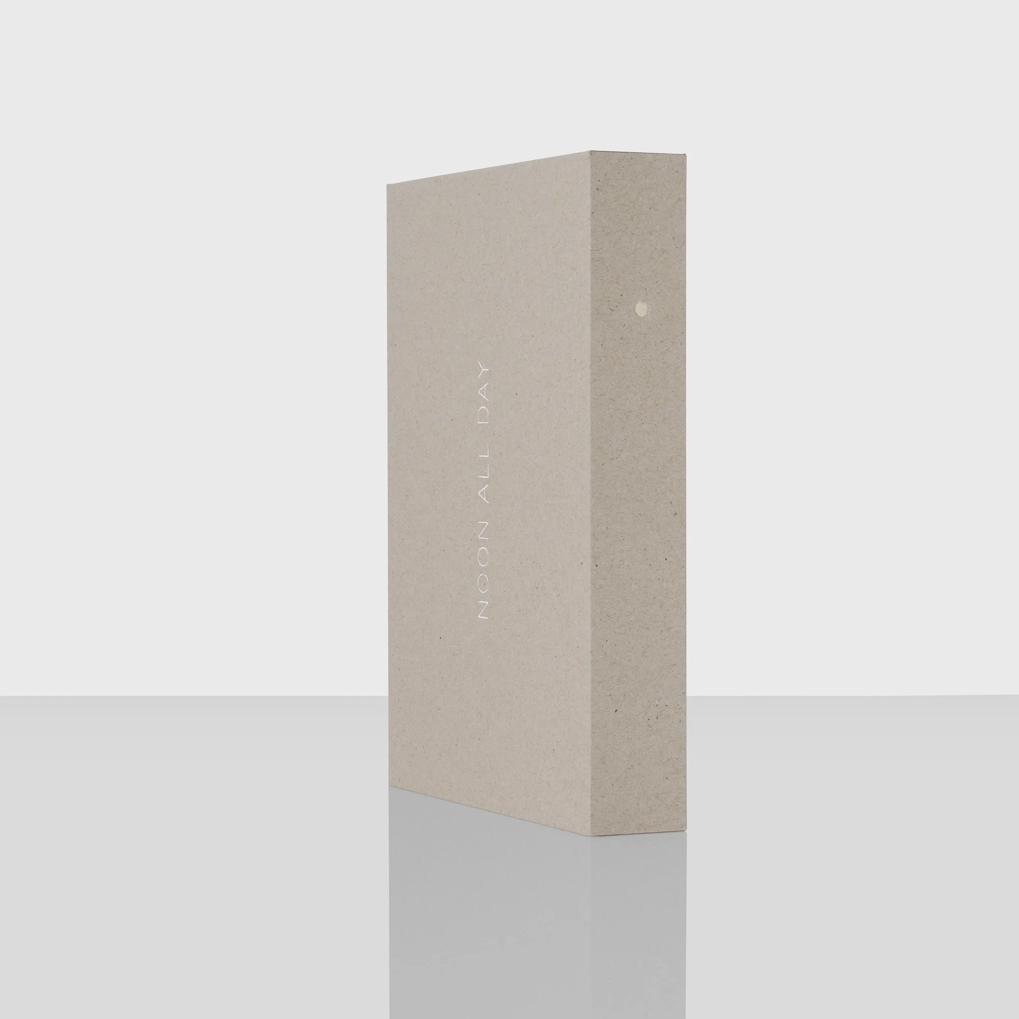 Een rechthoekige, beige, stenen structuur met een klein gat of opening op een van de zijden, geplaatst op een witte achtergrond.