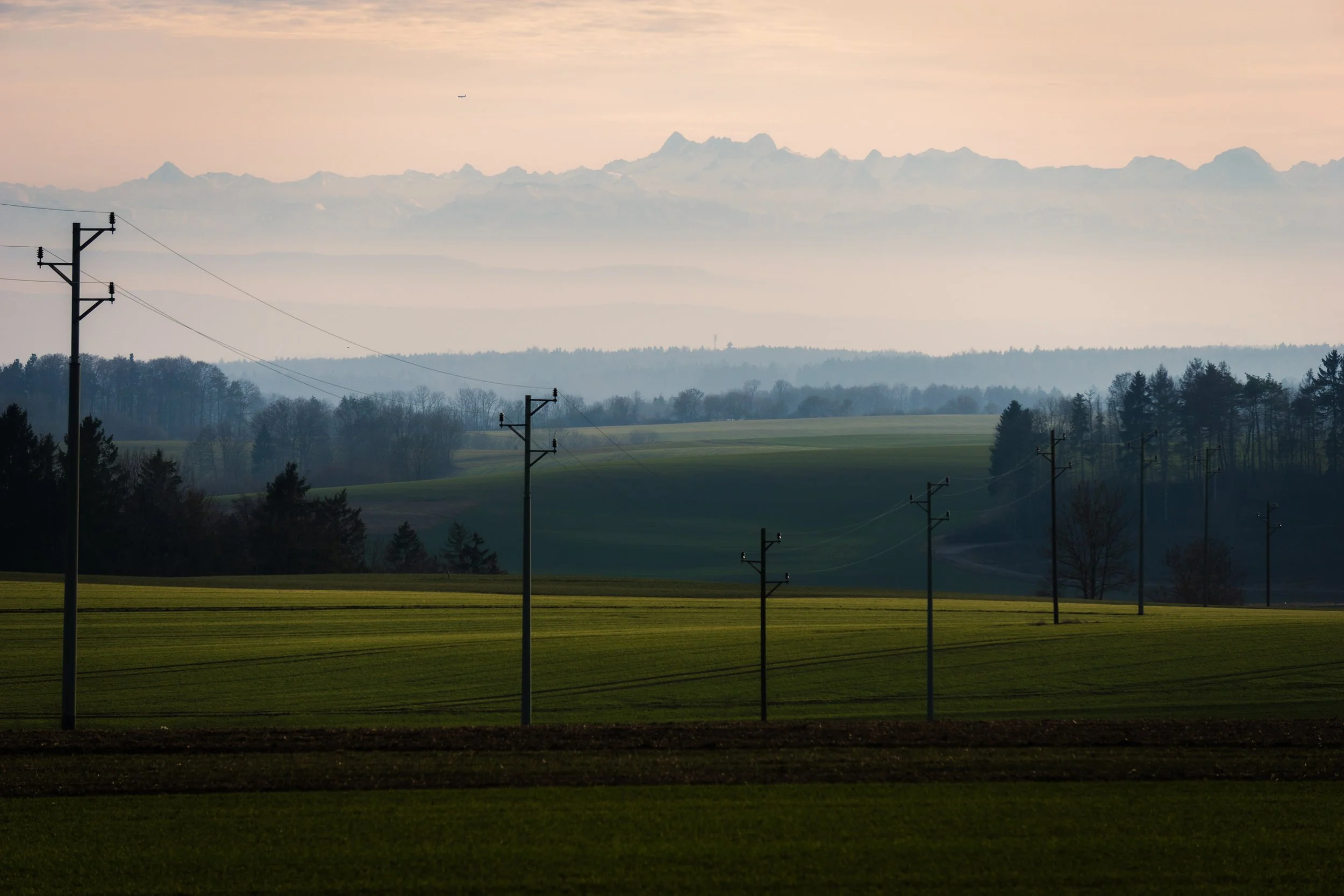 Rural electrical poles and distribution lines across open countryside.