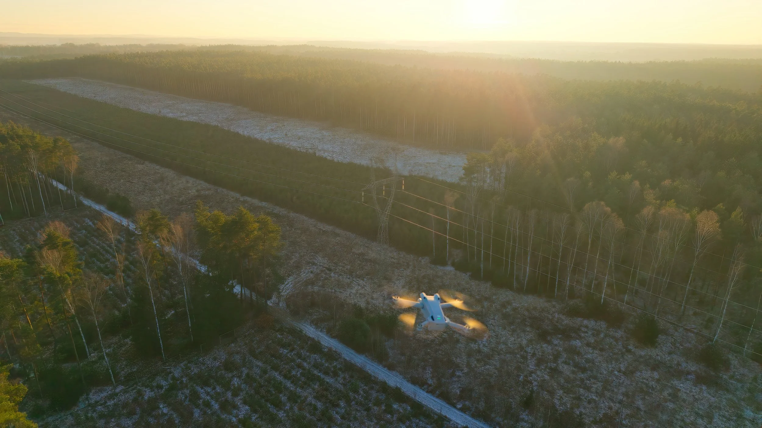 Drone inspecting overhead electrical transmission infrastructure.