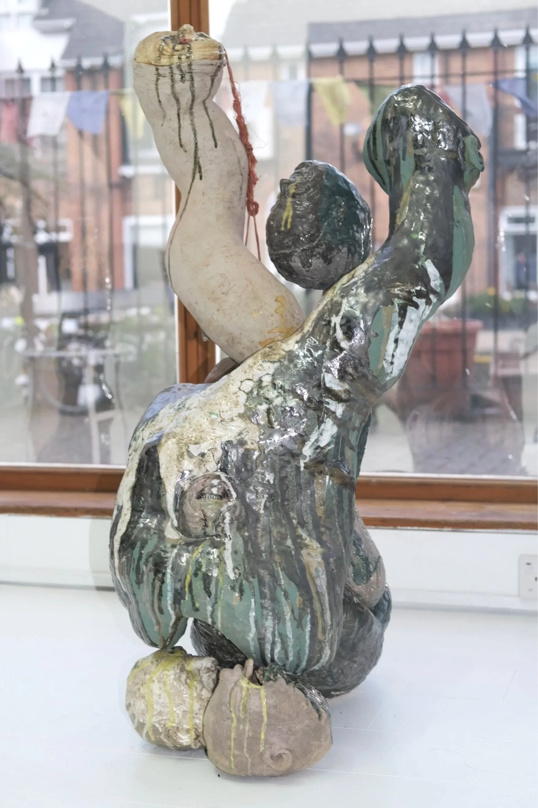 Simon Bedwell Glazed ceramic sculpture of figures displayed in front of a window at Darren Flook art gallery