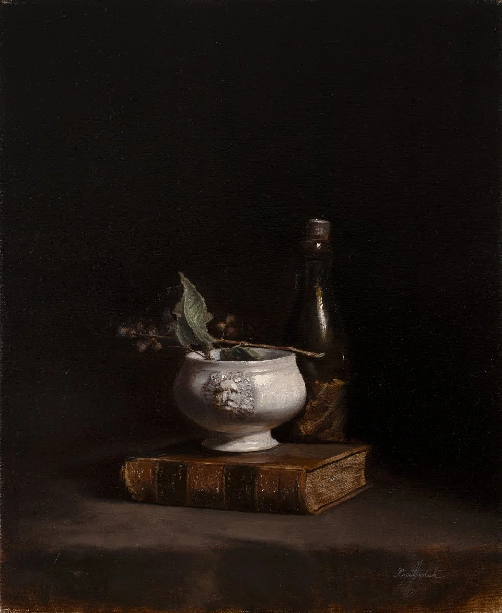 A still life painting featuring a white bowl with a floral decoration, a branch with green leaves and berries inside, an old leather-bound book, and a dark glass bottle, all set against a dark background.