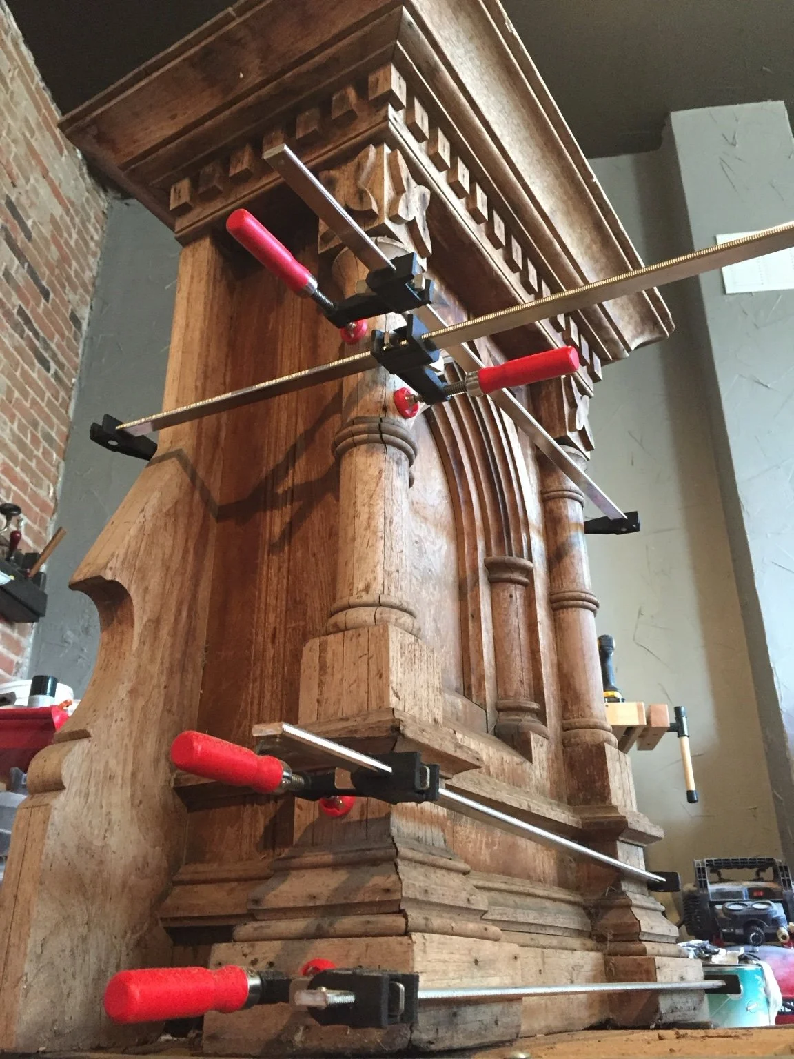 Furniture structural repair in progress with clamps at the Kunicki Restoration workshop in Denver.