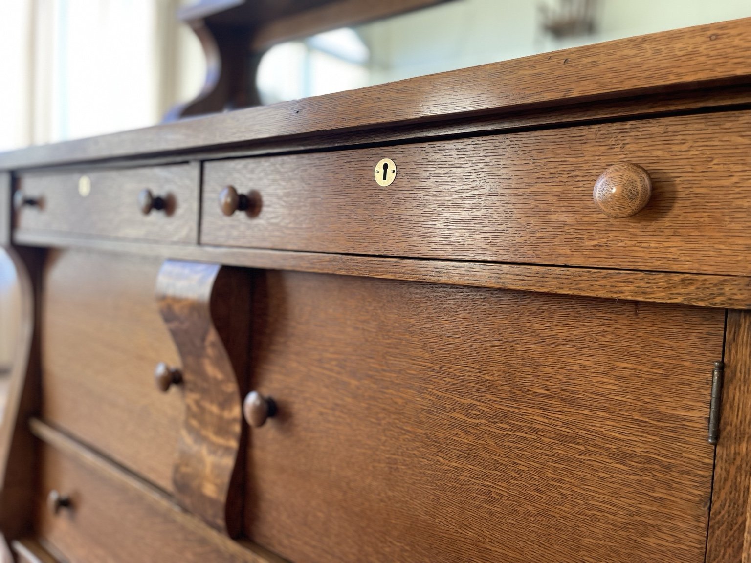 Detail of a restored antique wood chest showing drawers, hardware and original craftsmanship.