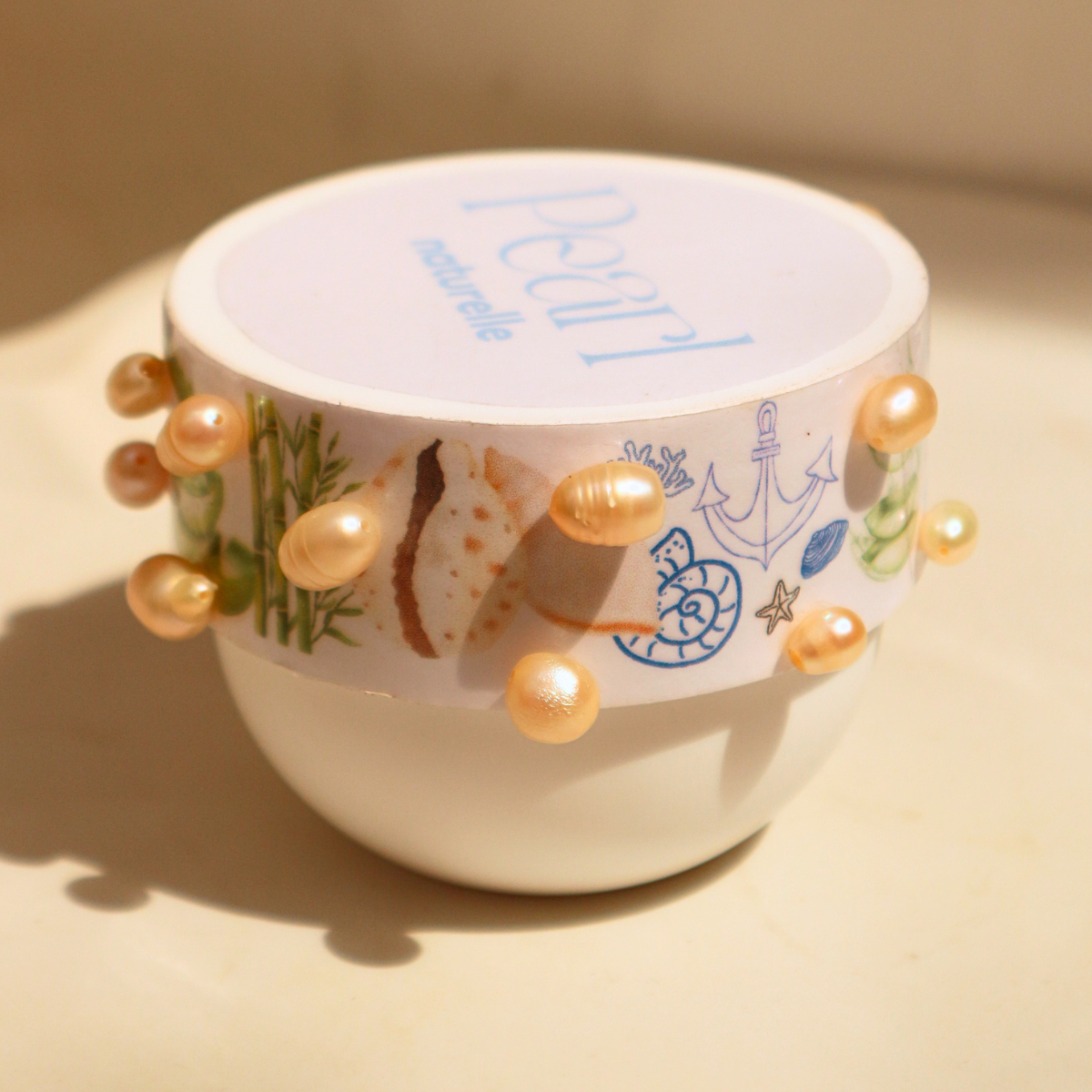 A container of Peppermint Exclusive cream decorated with pearl-like embellishments.