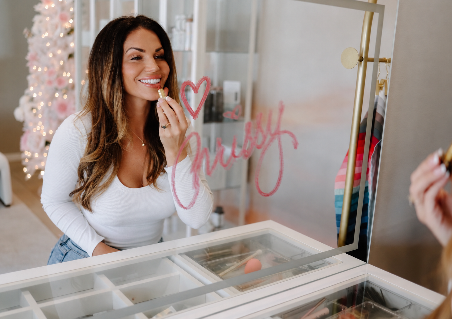 Chrissy Jacobs applying lipstick in her studio, showing the shades she helps women 40+ find in a makeup consultation